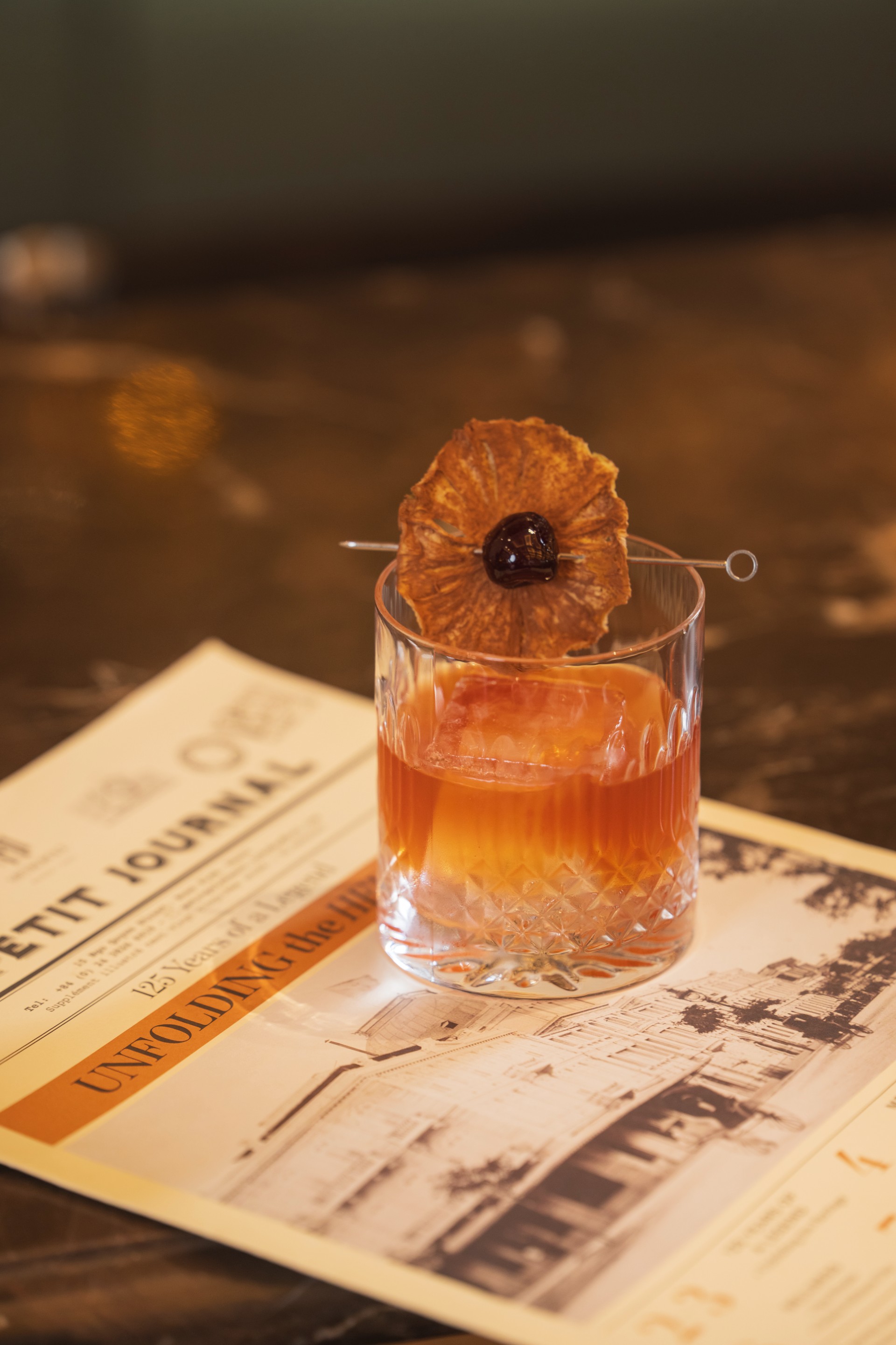 a glass with a drink and a flower on it