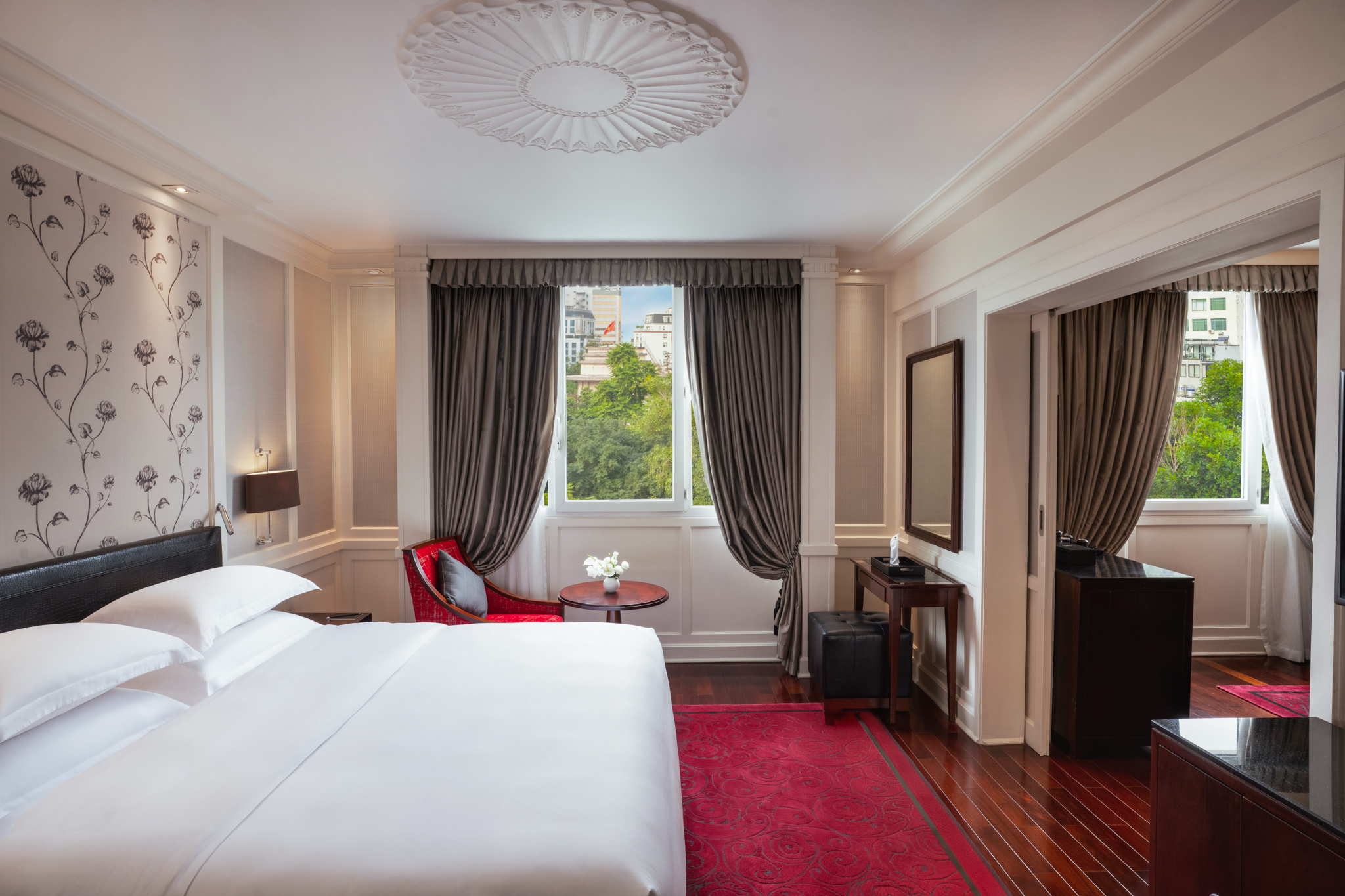 a room with a bed and a red rug