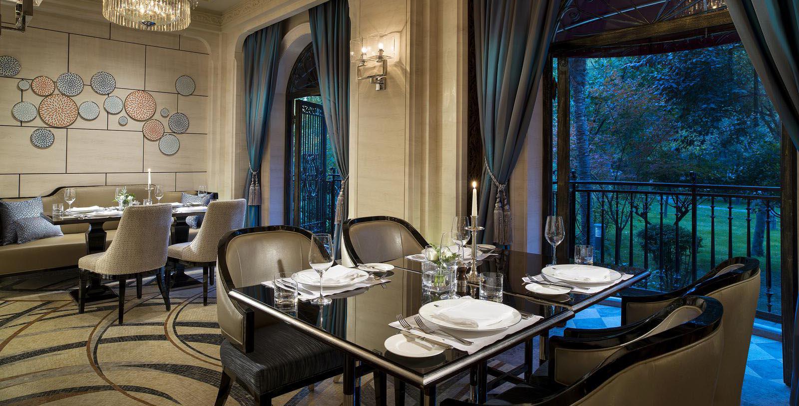 a dining room with a table set with white plates and silverware