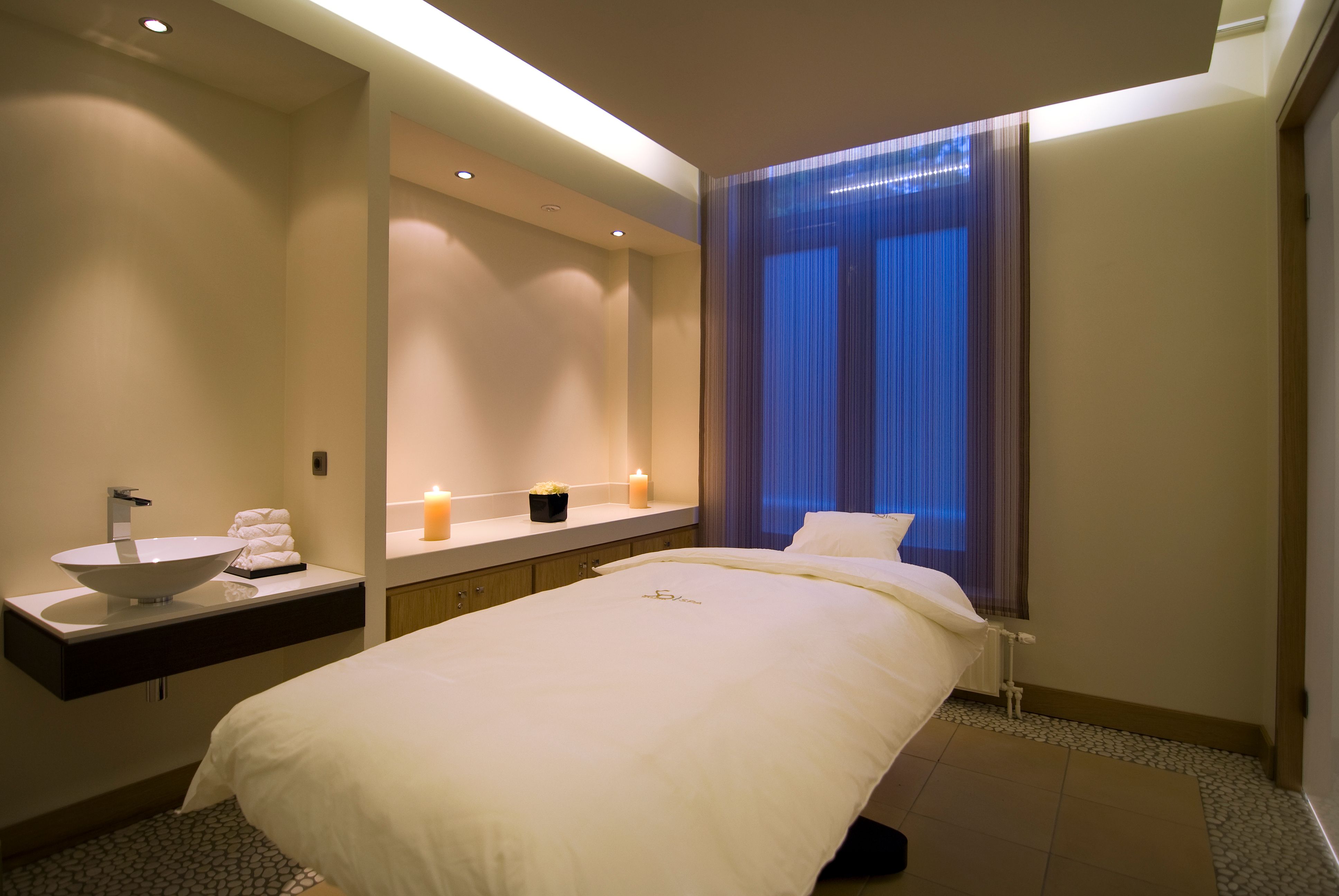 a massage room with a bed and candles