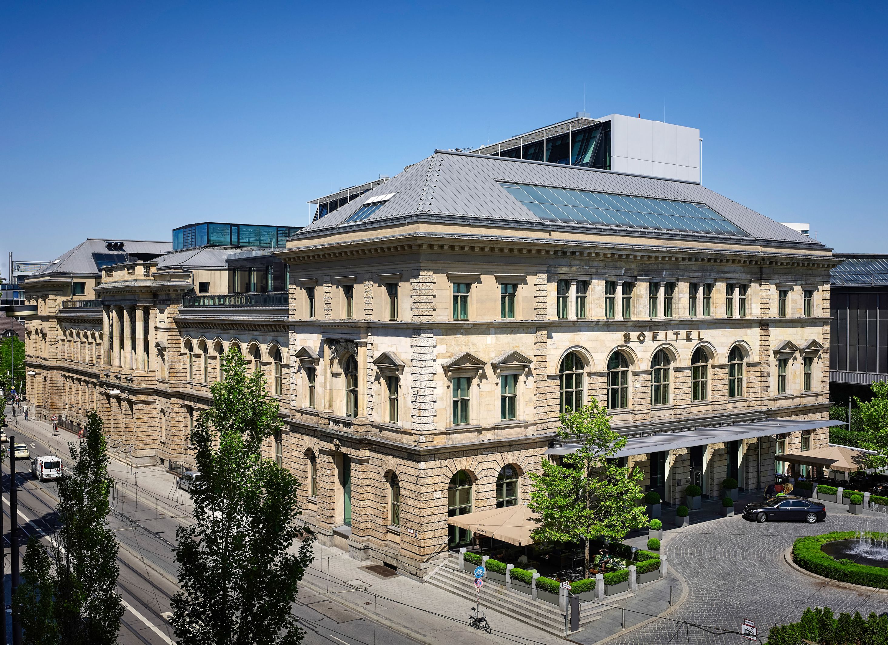 a large building with a street and trees