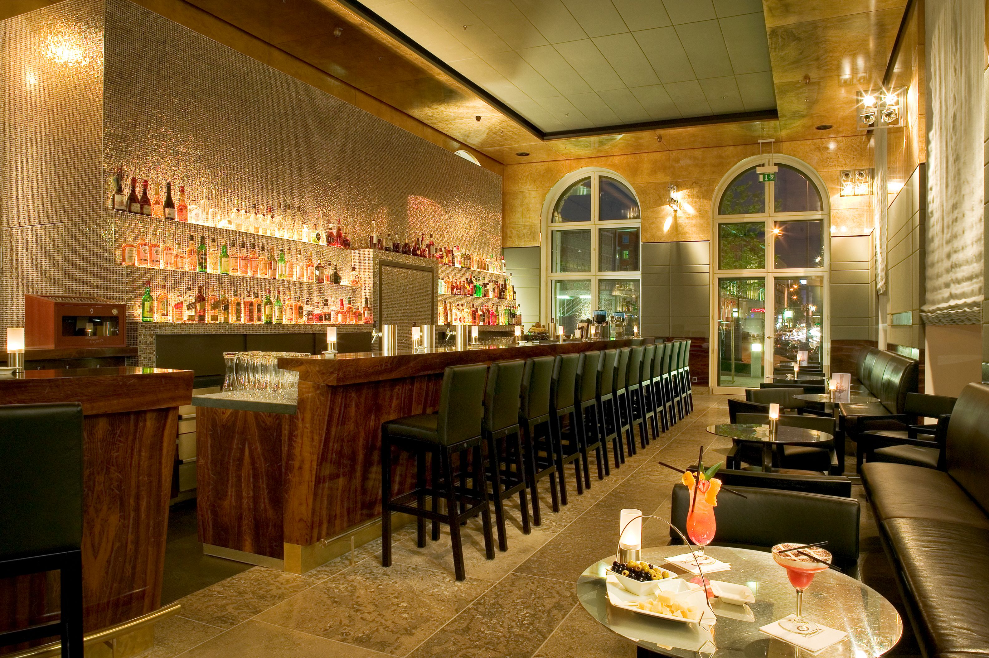 a bar with many chairs and a table with drinks