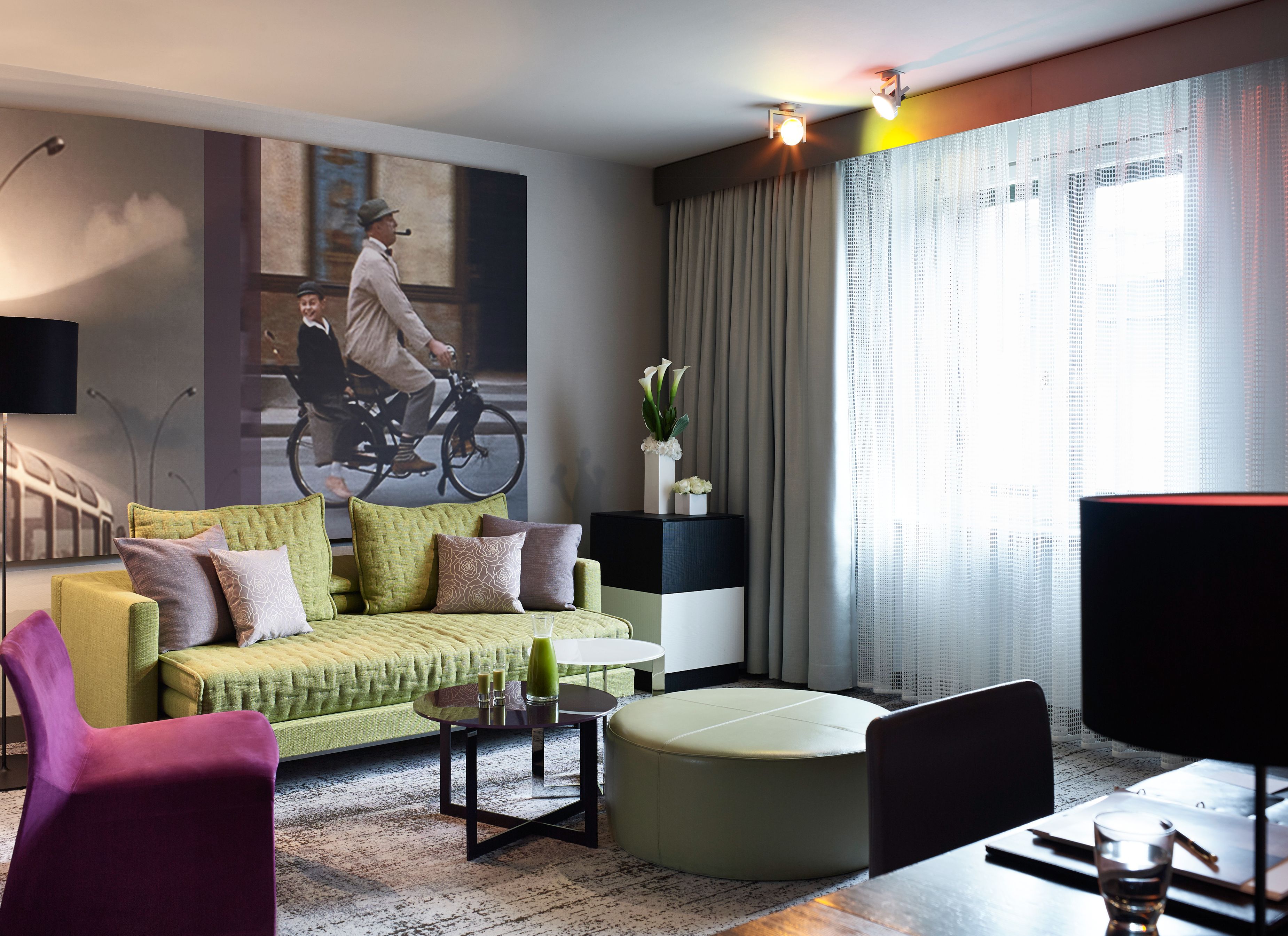 a living room with a couch and a picture of two men on a bicycle