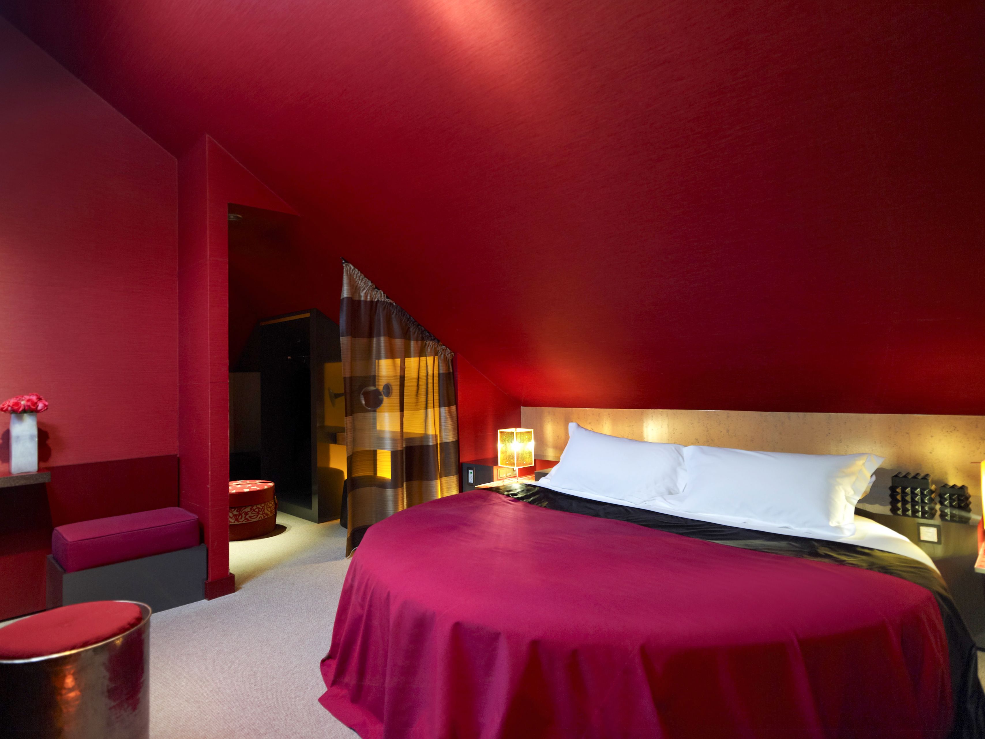 a bedroom with a round bed and a red ceiling