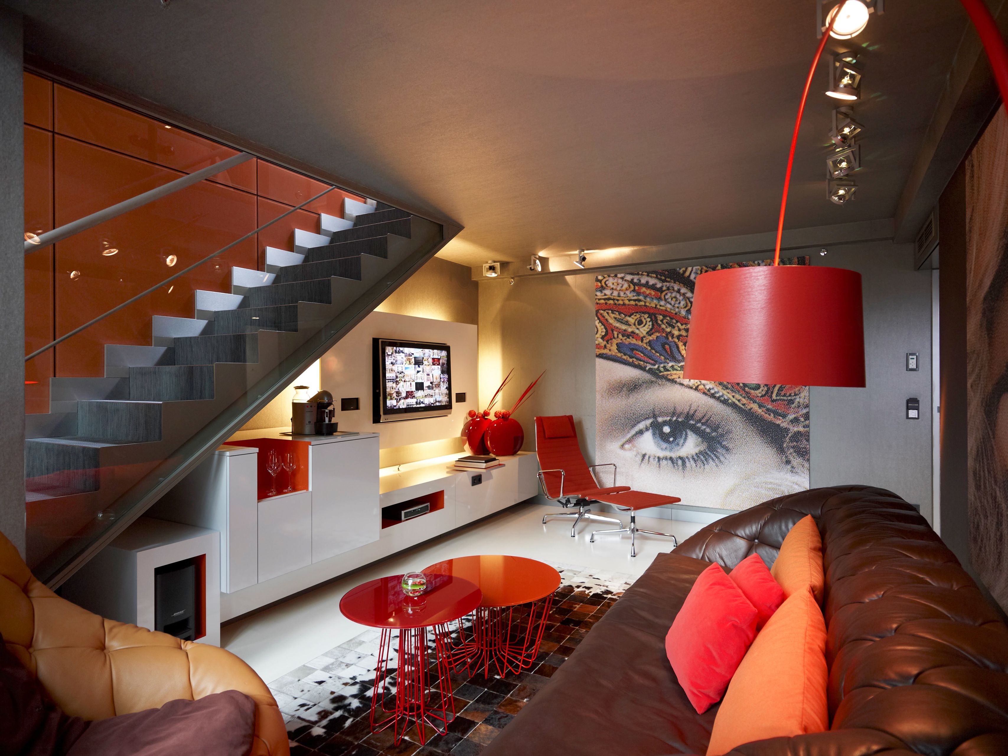 a living room with a red lamp and a couch