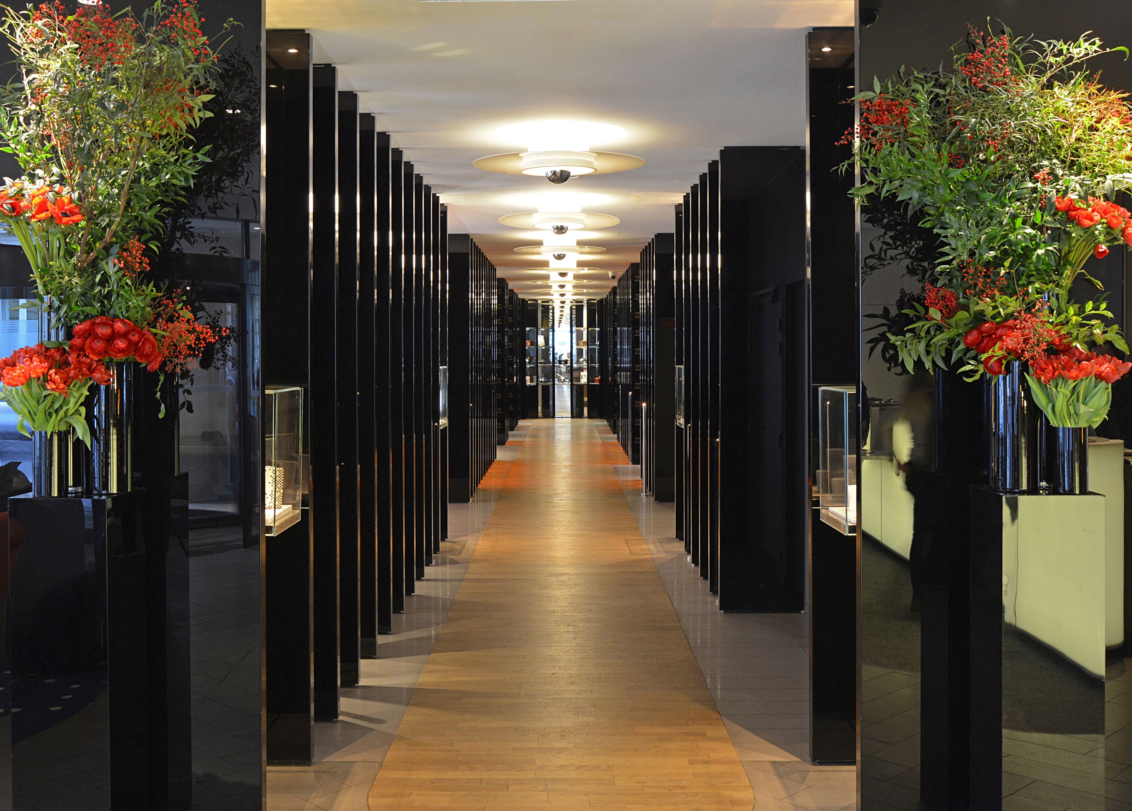 a hallway with black columns and flowers