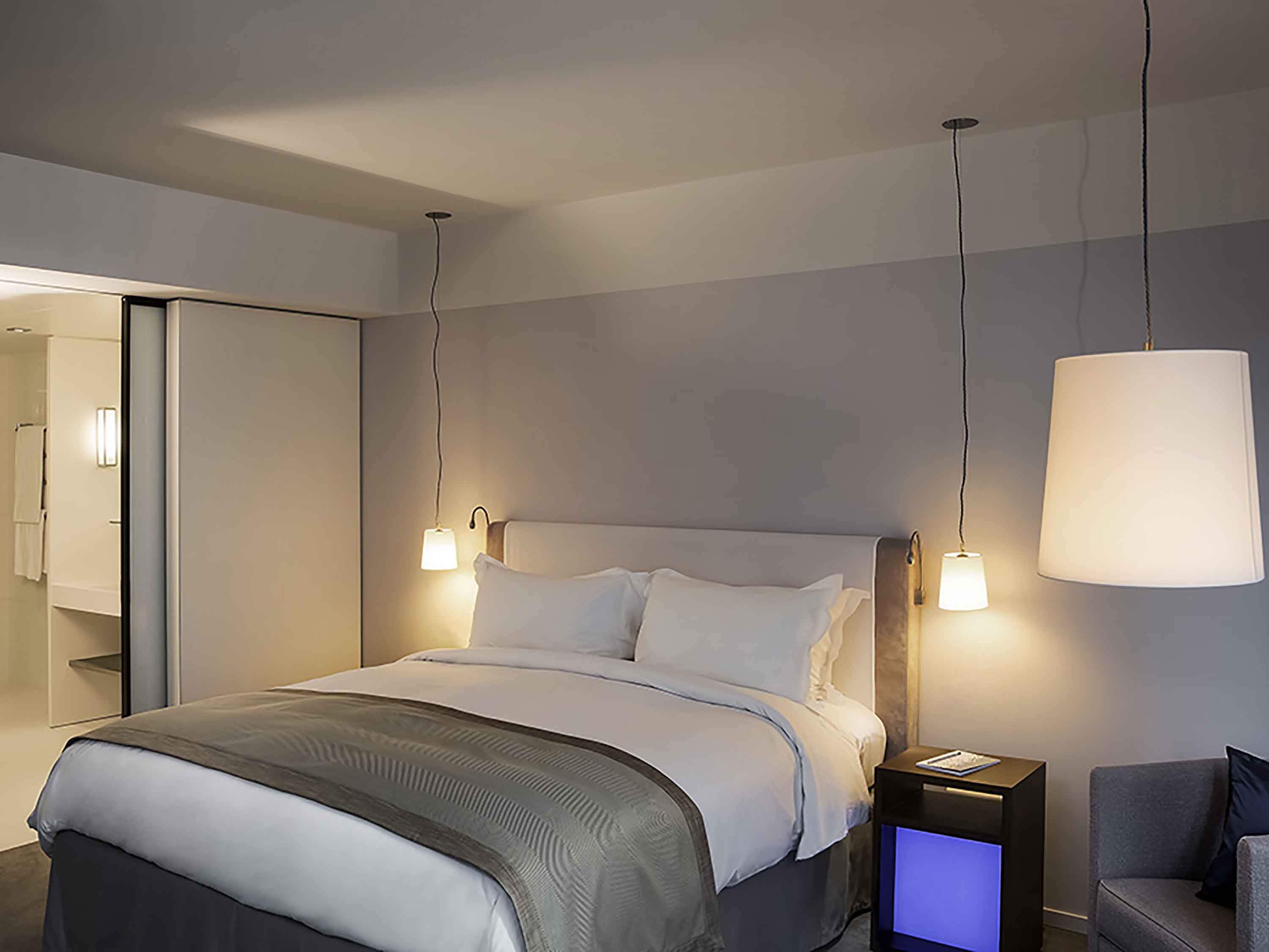 a bed with lamps from the ceiling