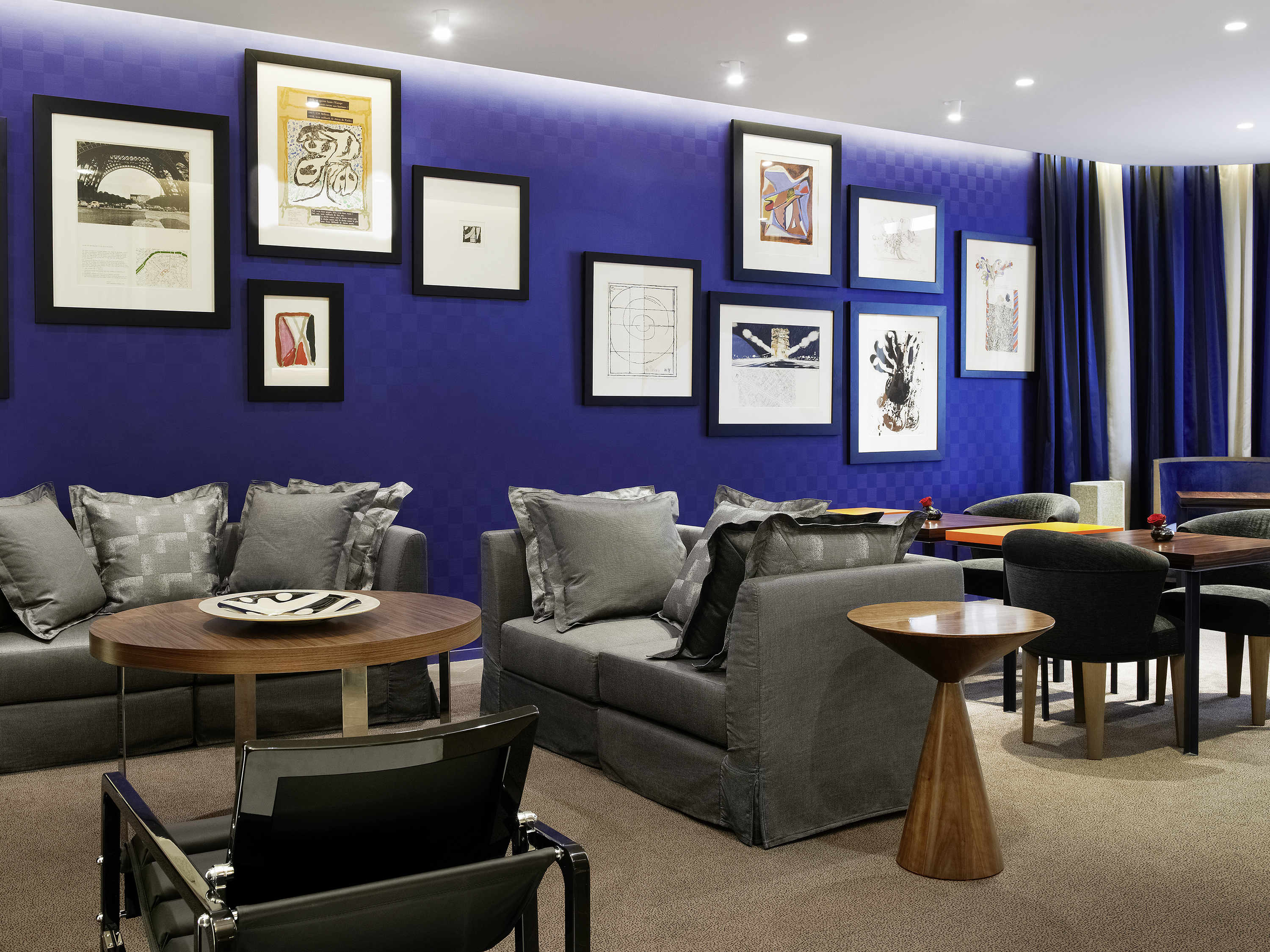a room with a blue wall and a couch and tables