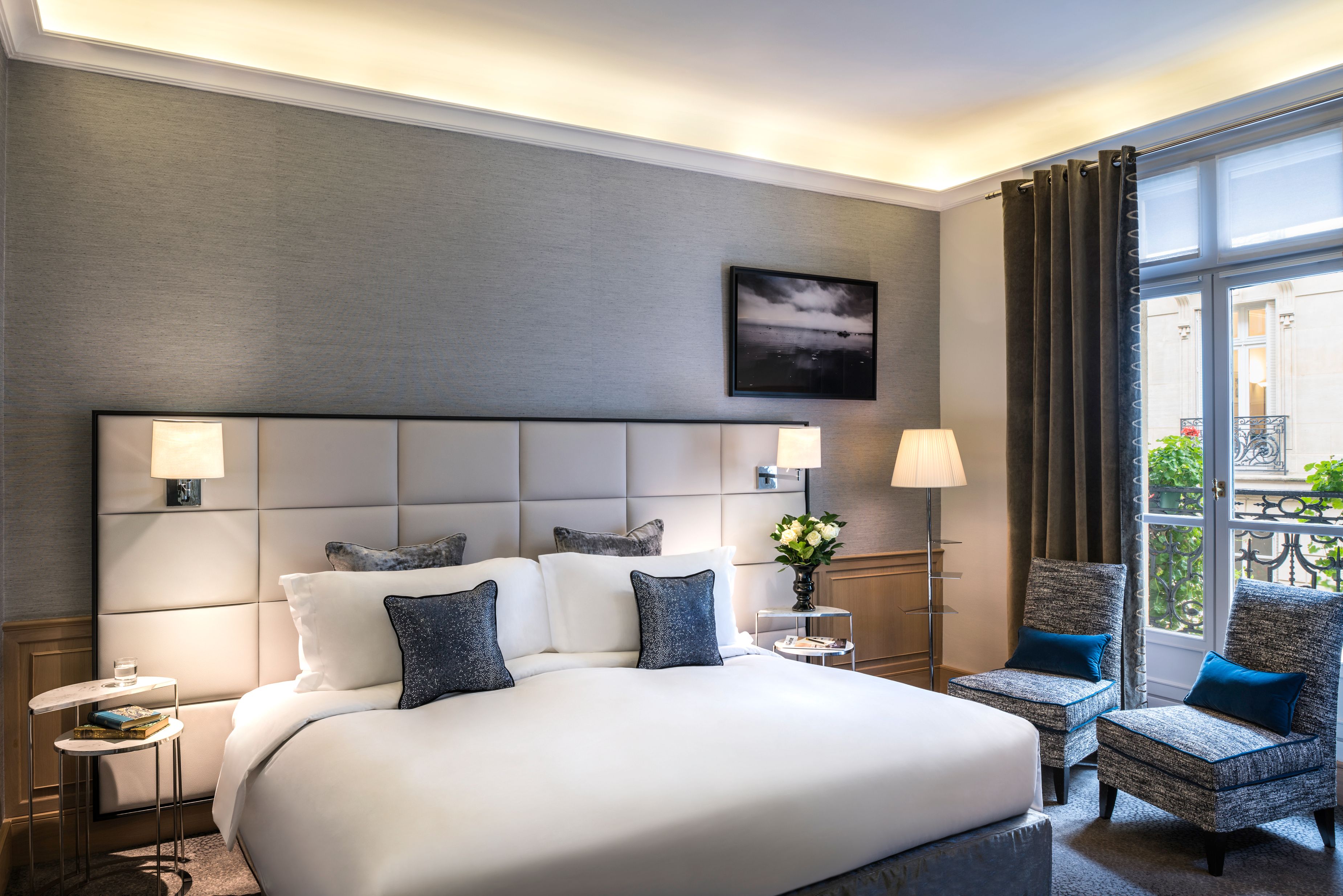 a bedroom with a bed and chairs