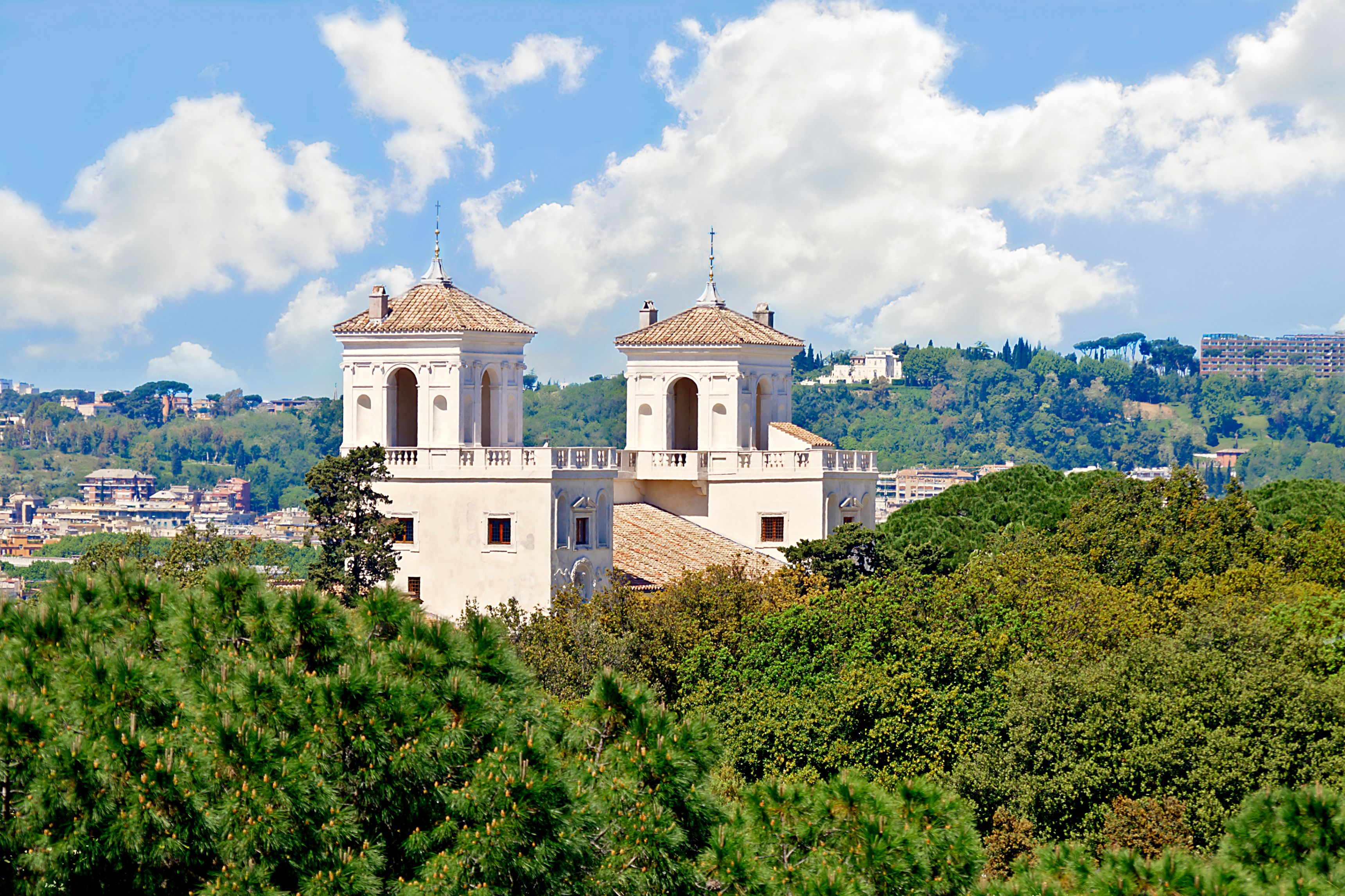 a building with towers and trees in the background