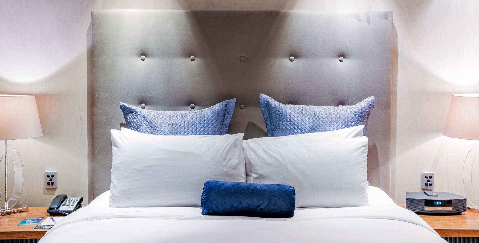 a bed with pillows and a blue pillow on it