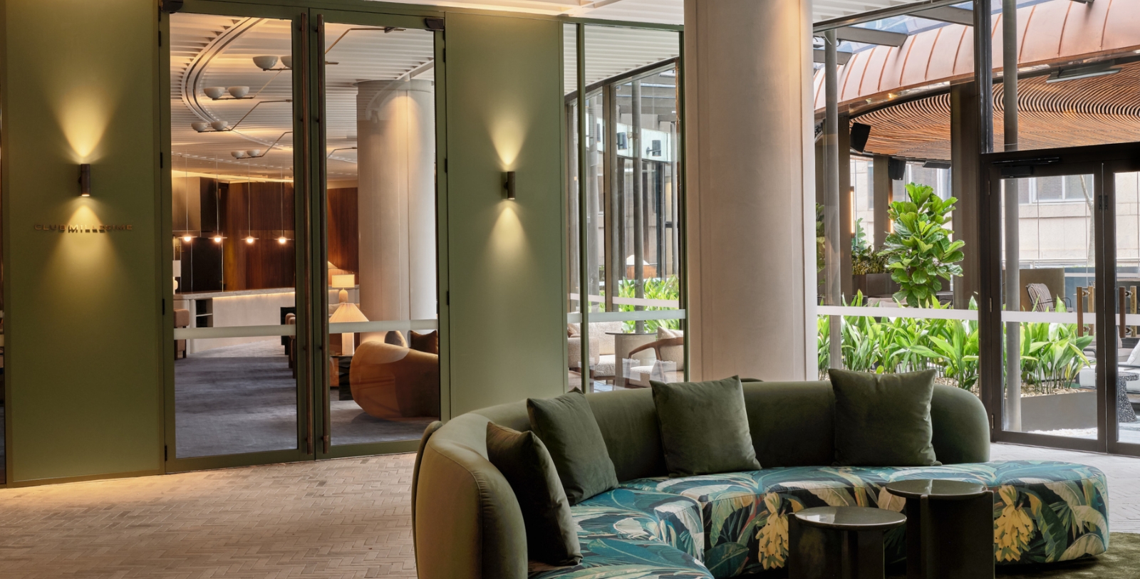 a round couch in a room with glass doors