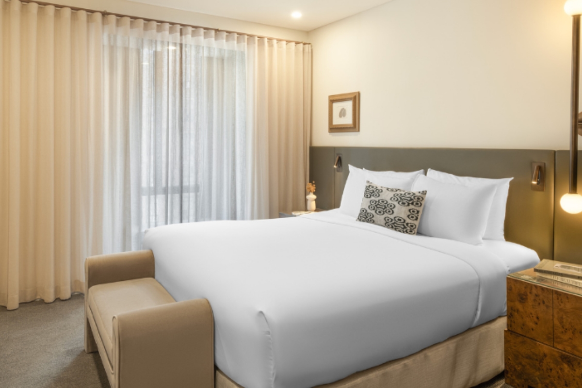 a bed with a couch and a lamp in a room