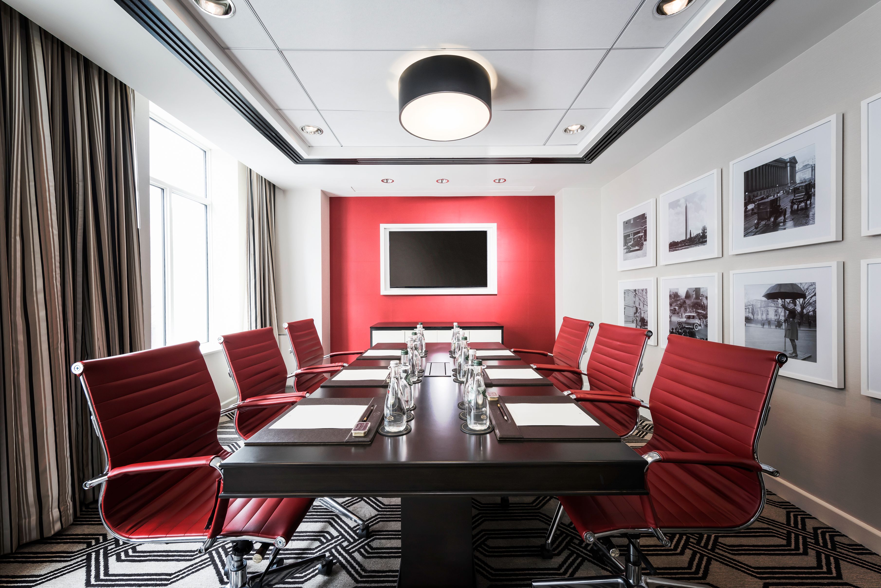 a conference room with red chairs and a black table