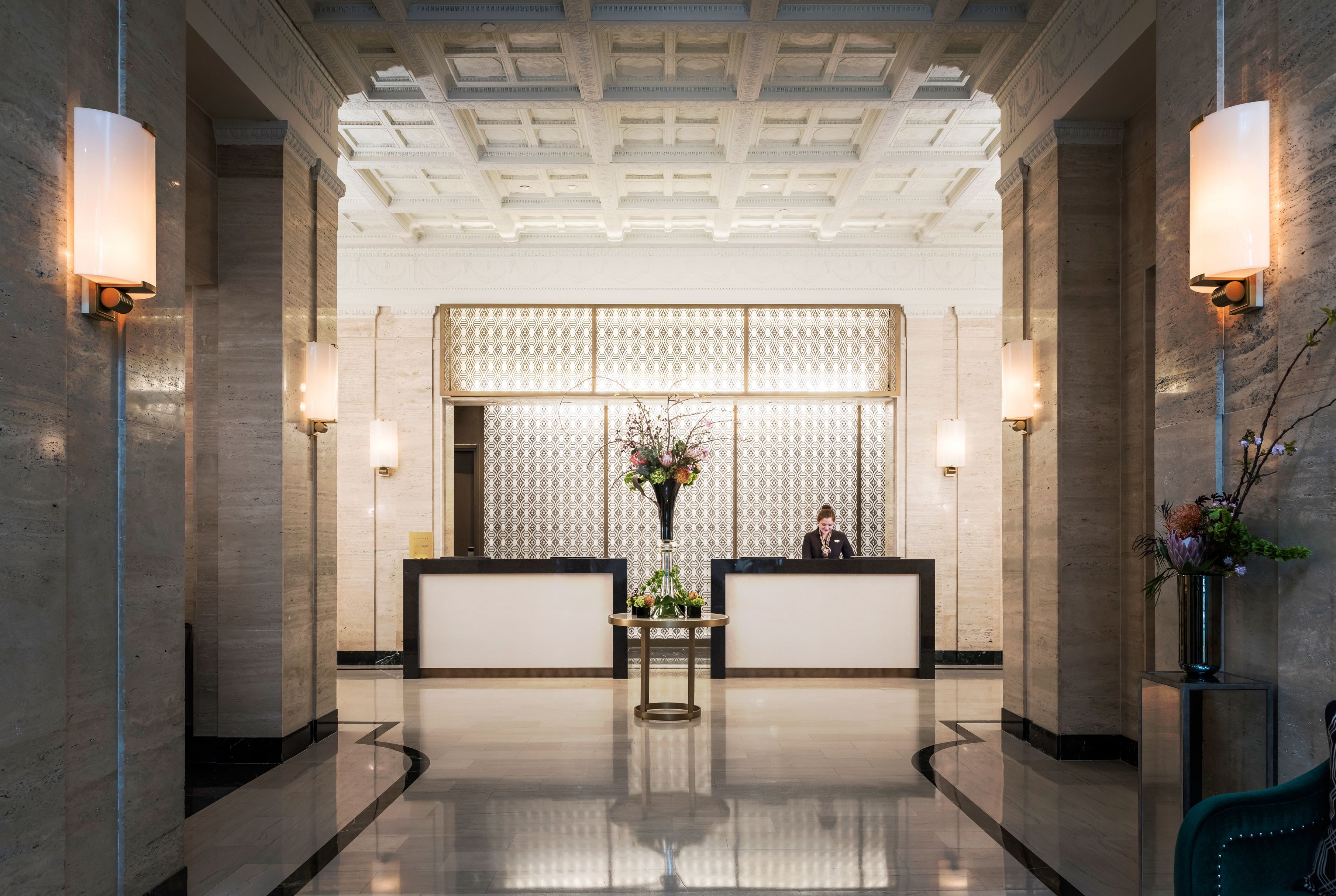 a man standing behind a reception desk in a hotel