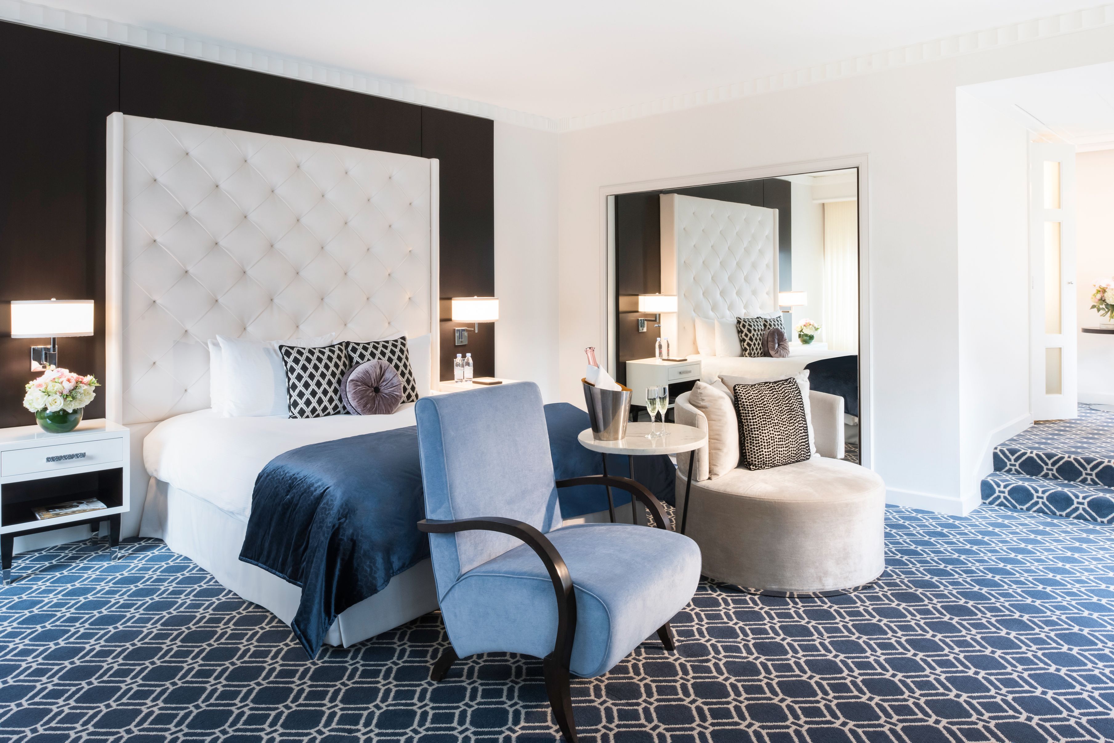 a room with a bed and chairs