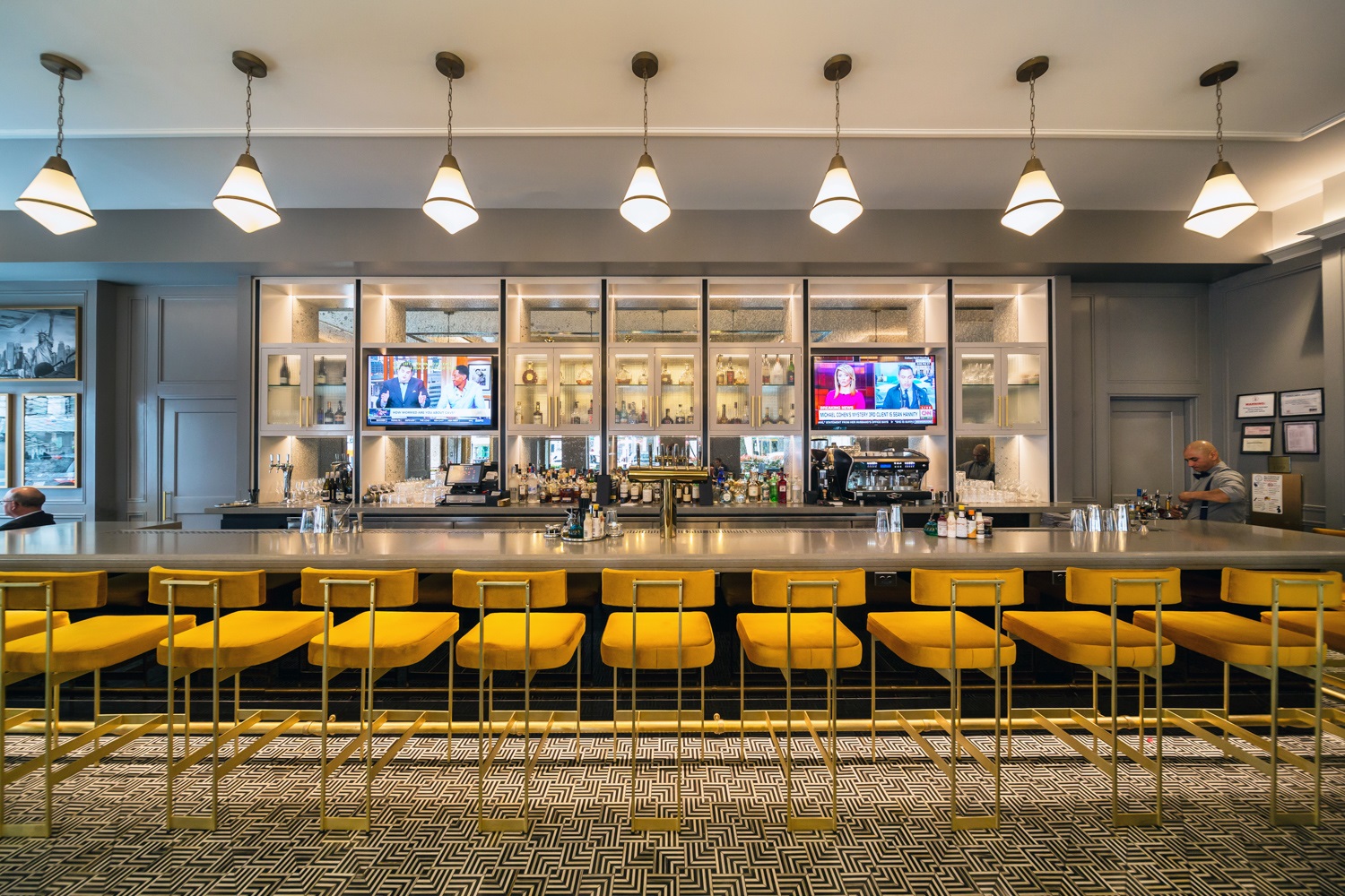 a bar with yellow stools and a row of chairs