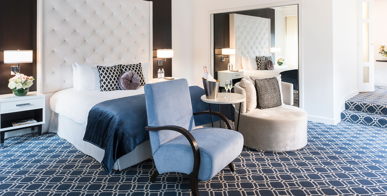 a room with a bed and chairs