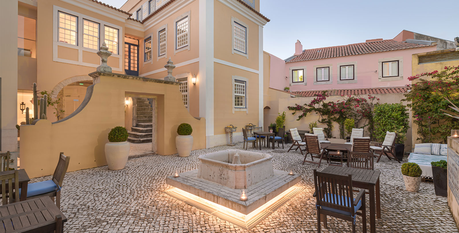 a courtyard with a fountain and chairs