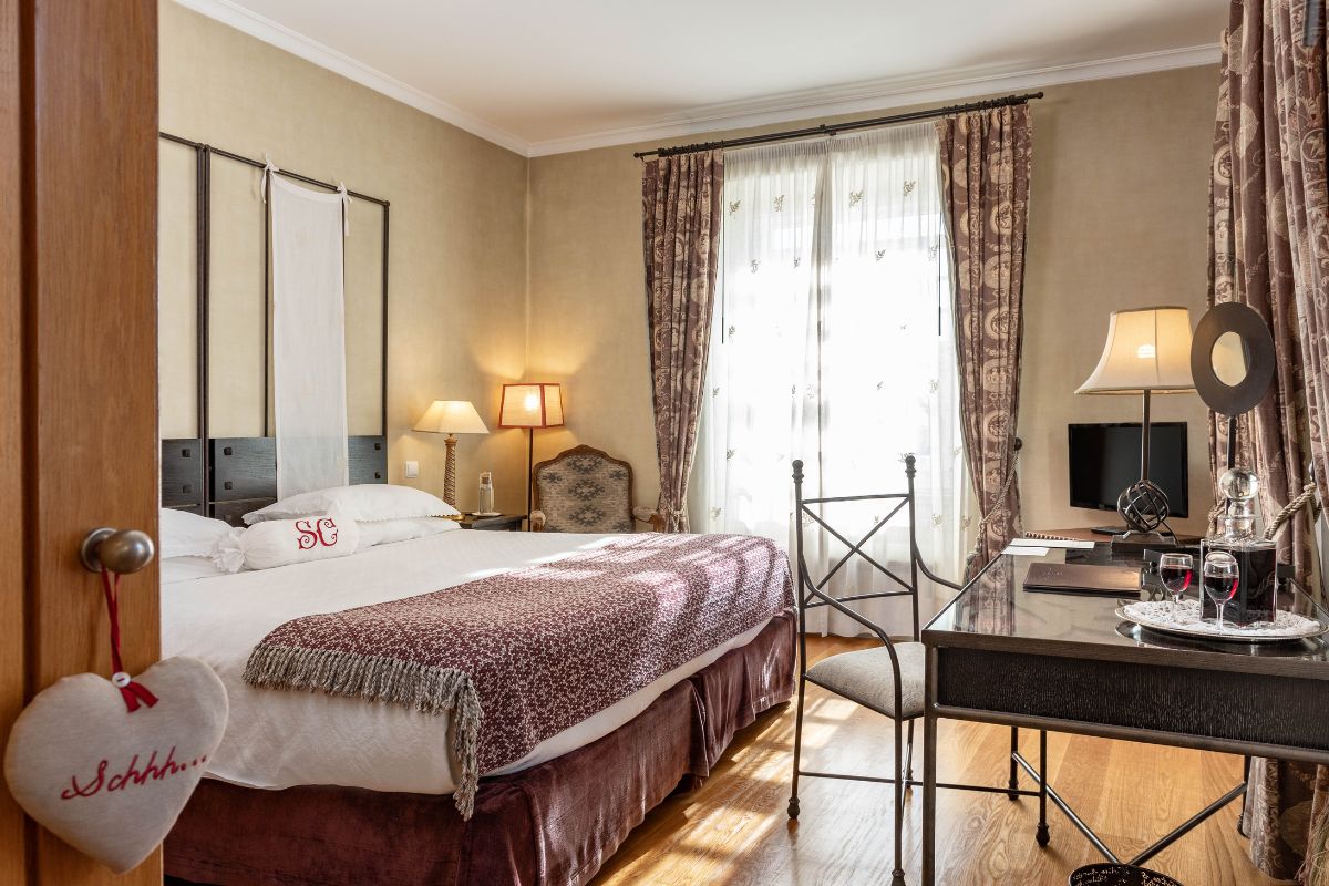 a bedroom with a desk and a bed