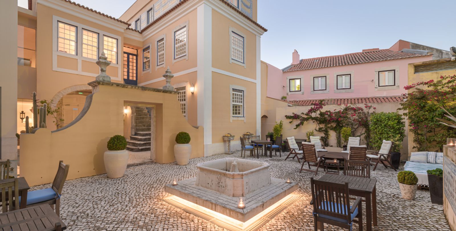 a courtyard with a fountain and chairs