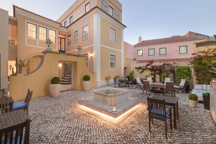 a courtyard with a fountain and chairs