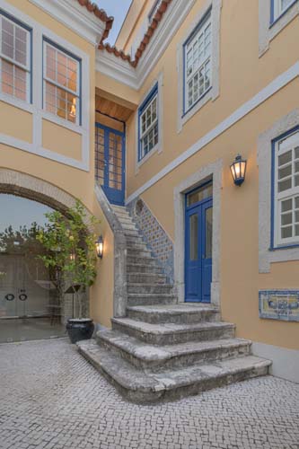 a building with stairs and blue doors