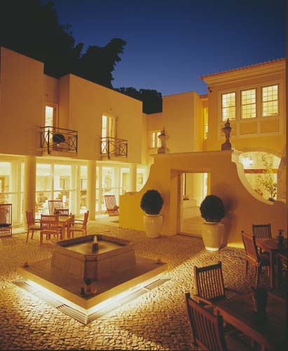 a courtyard with a fountain and chairs