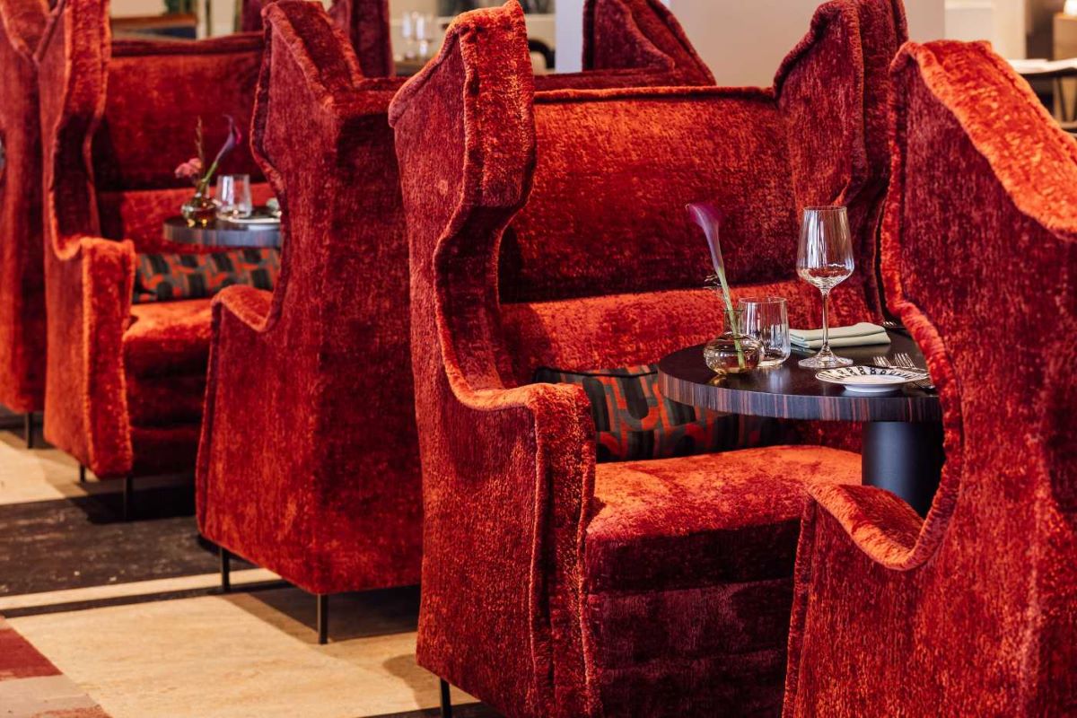 a group of red chairs with a table and glasses on it