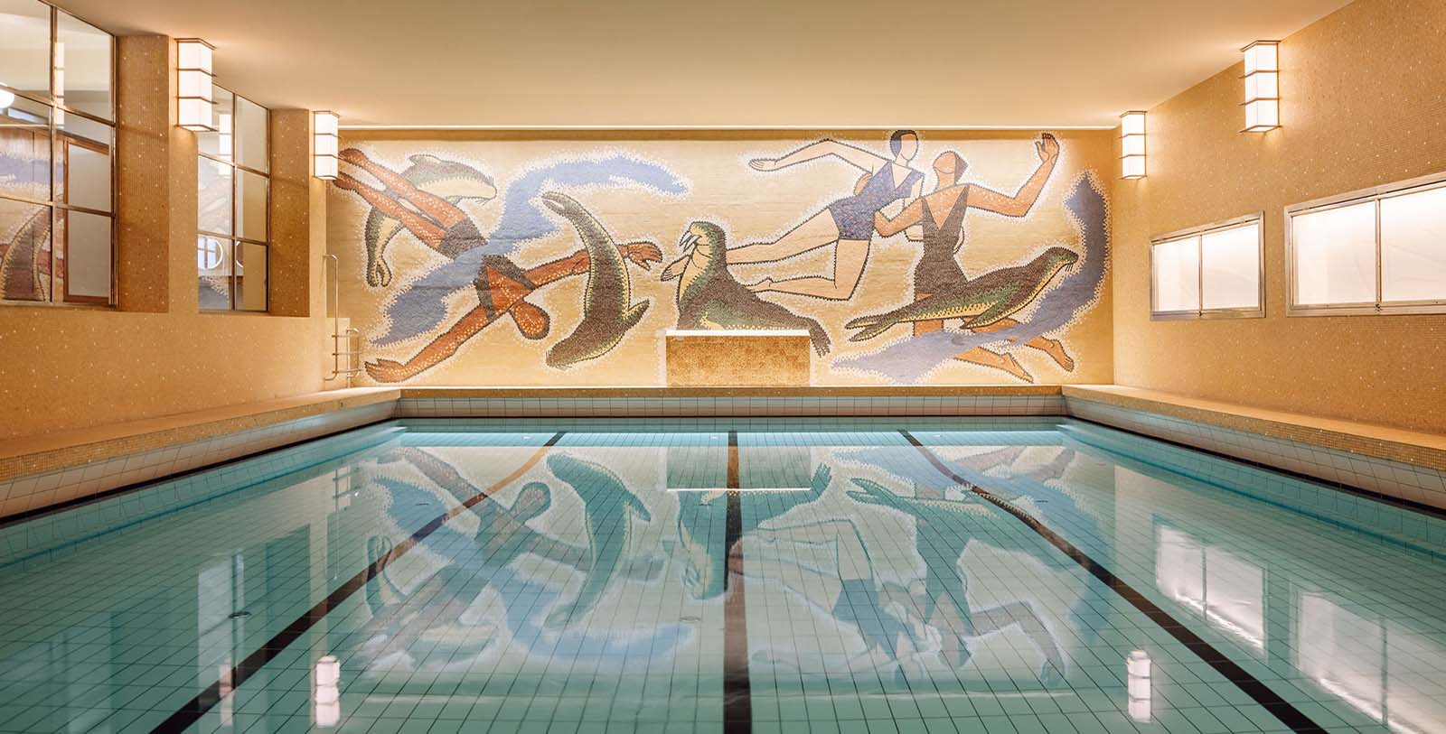 a swimming pool with a mosaic wall and a mural of people