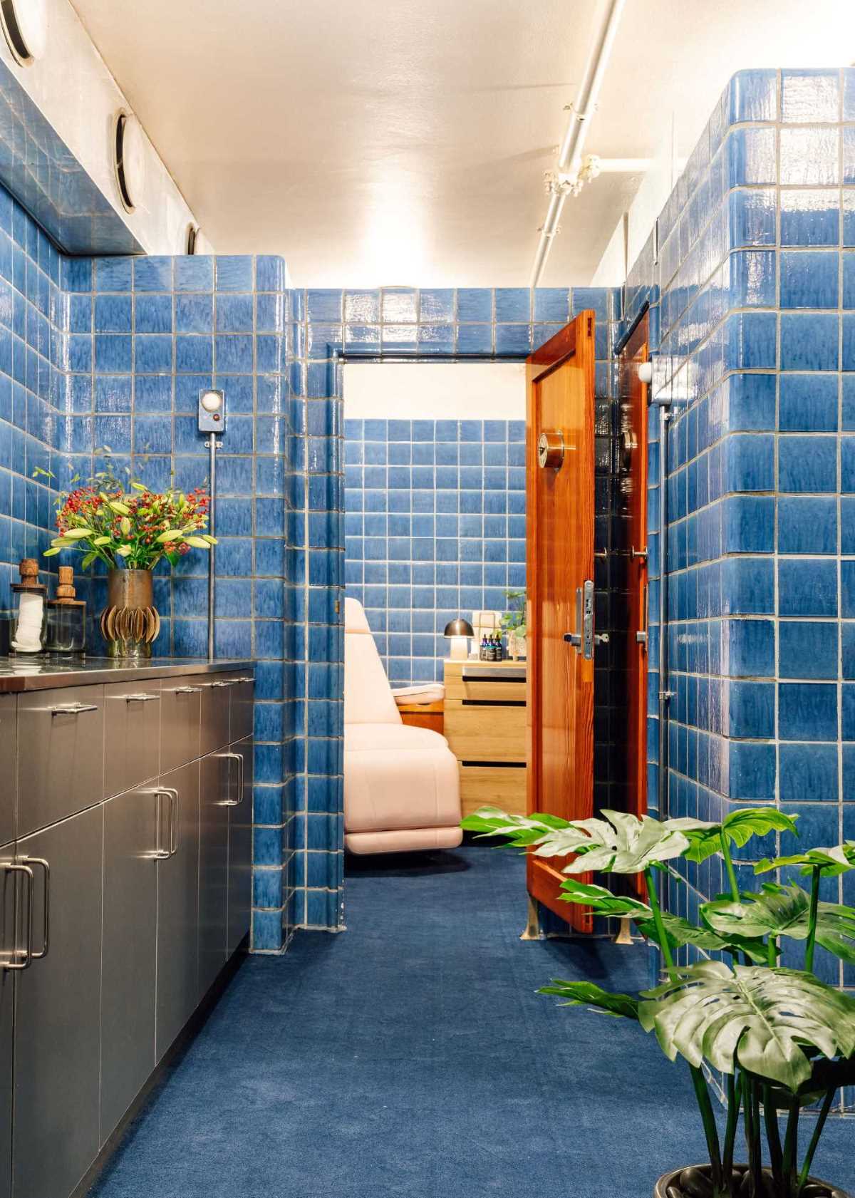 a room with blue tile walls and a white couch