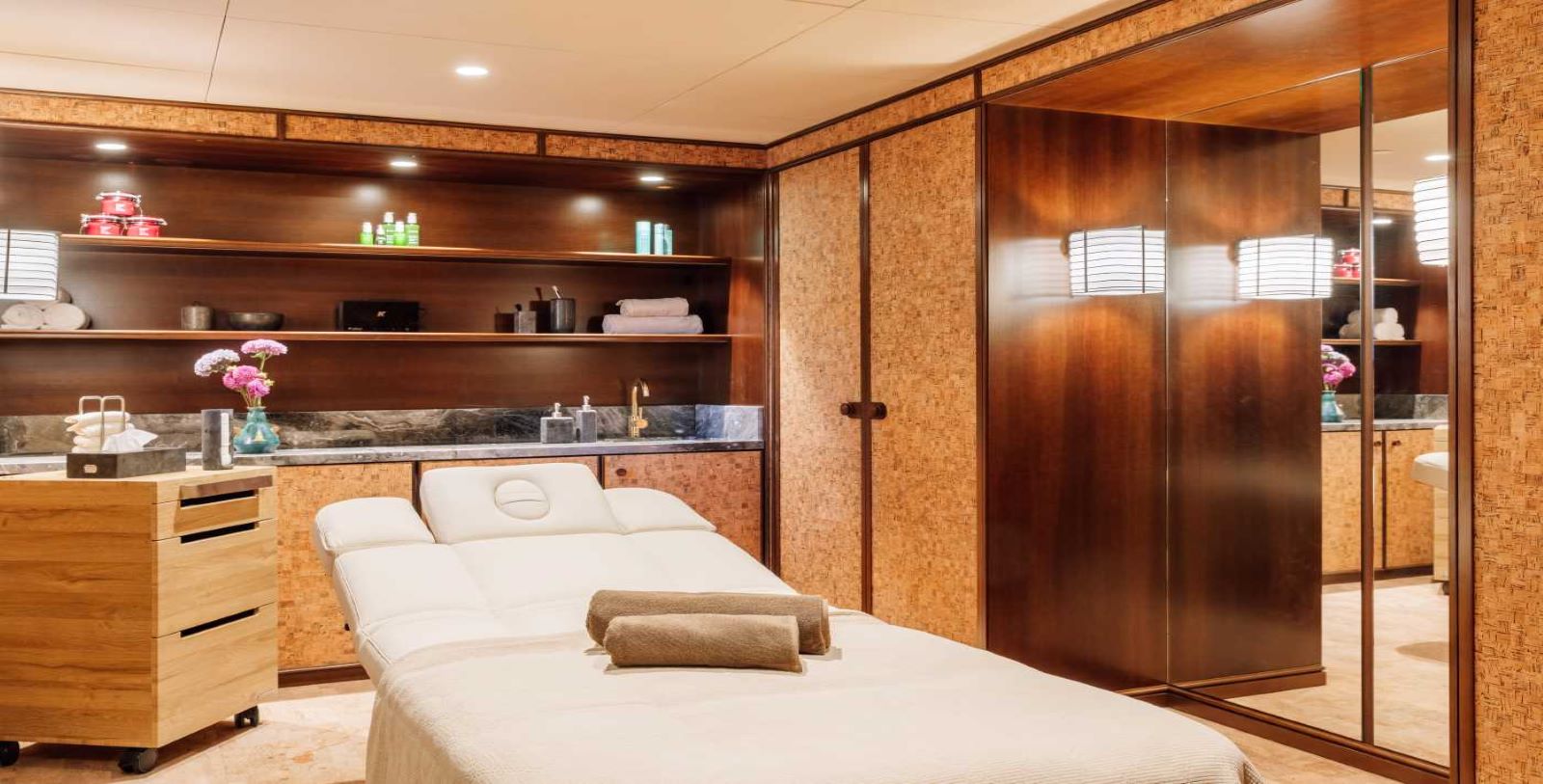 a massage room with a bed and shelves