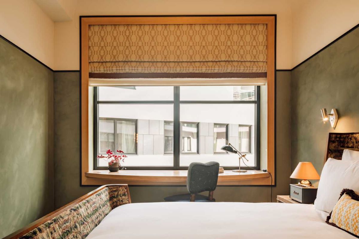 a bed with a chair and a window