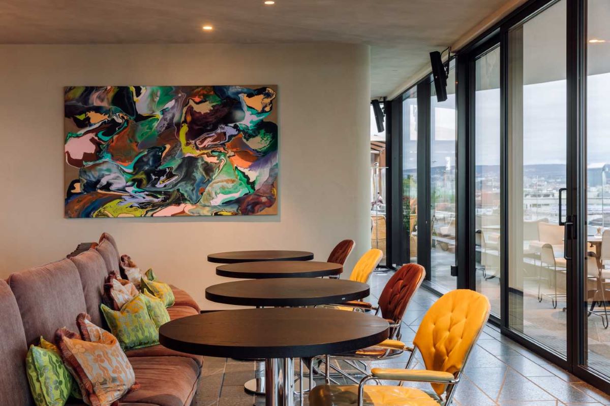 a room with a painting and tables