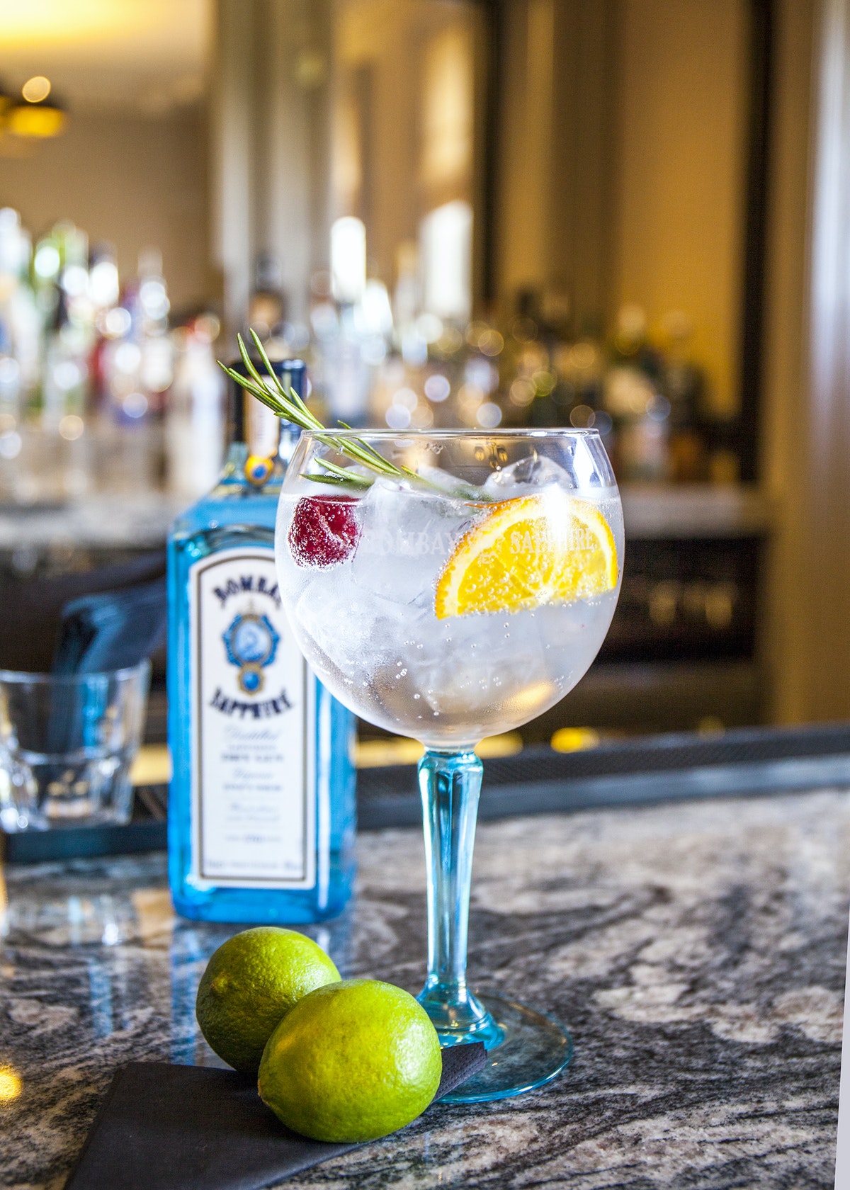 a glass of liquid with ice and fruit on a counter