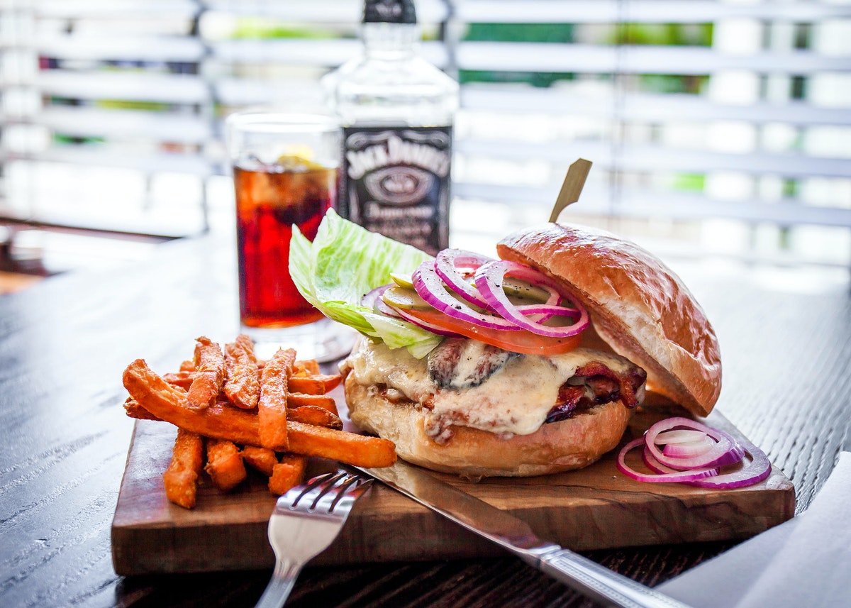 a burger and fries on a wooden board