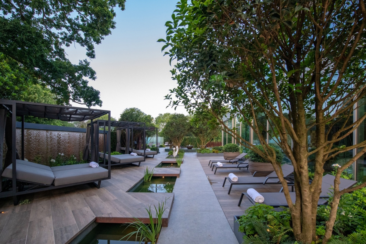 a pool area with lounge chairs and trees