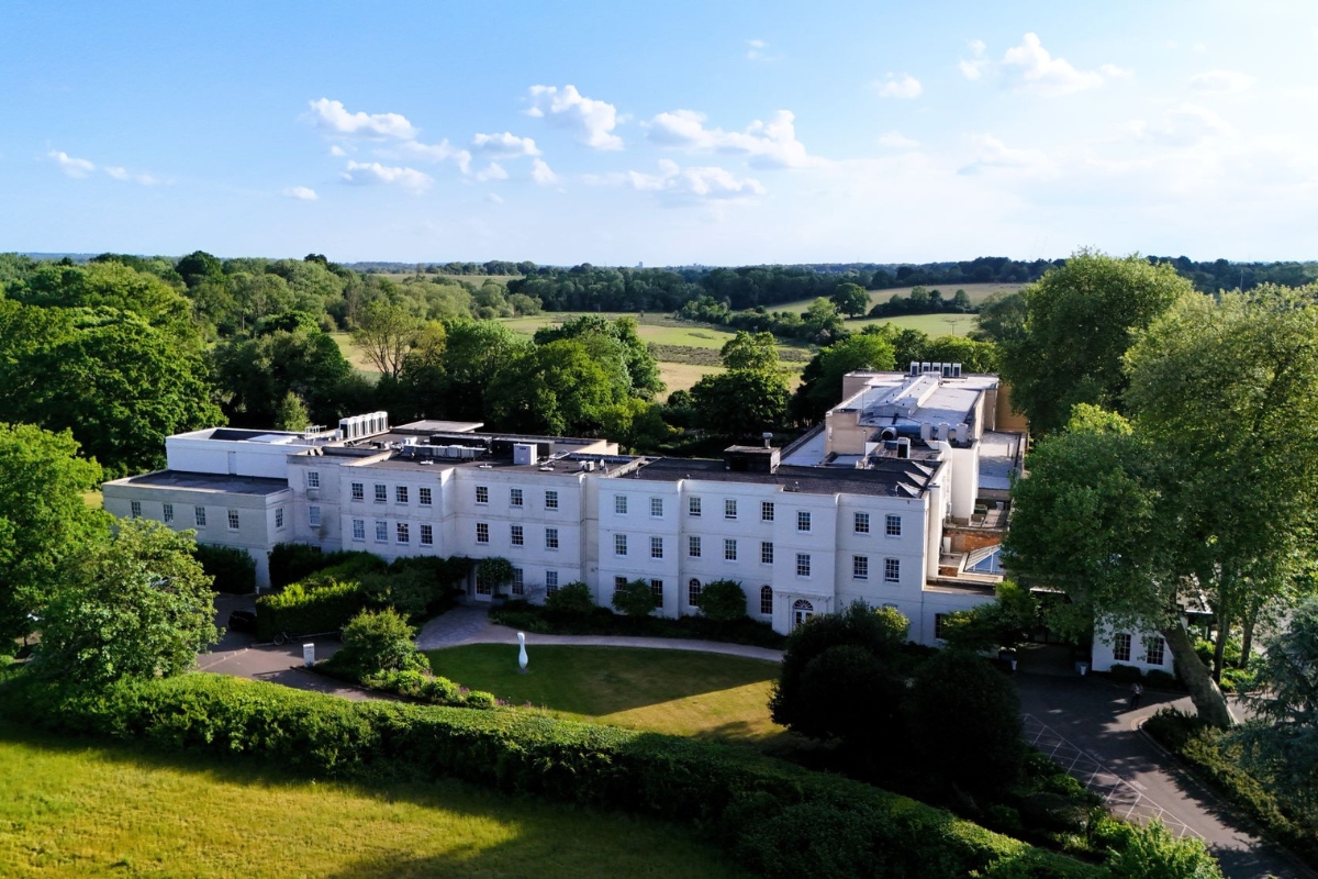 a large white building with trees and grass