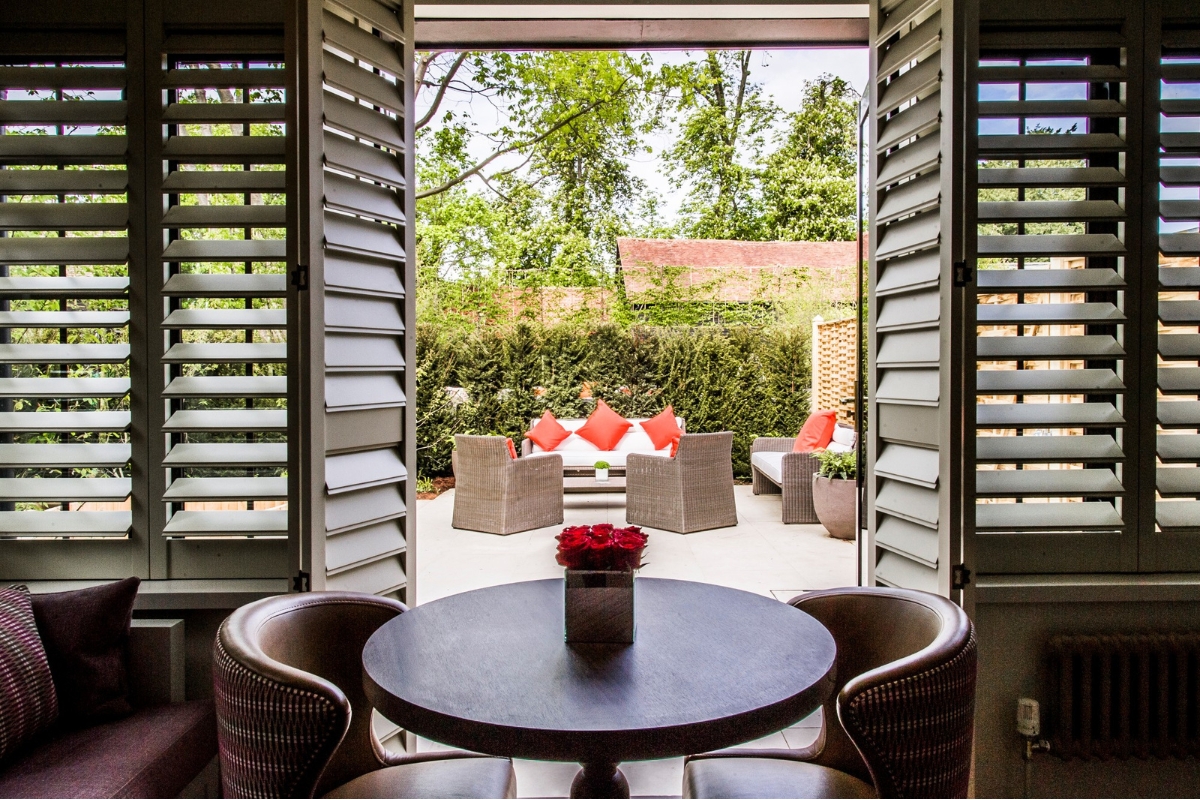 a table and chairs outside with a view of a garden