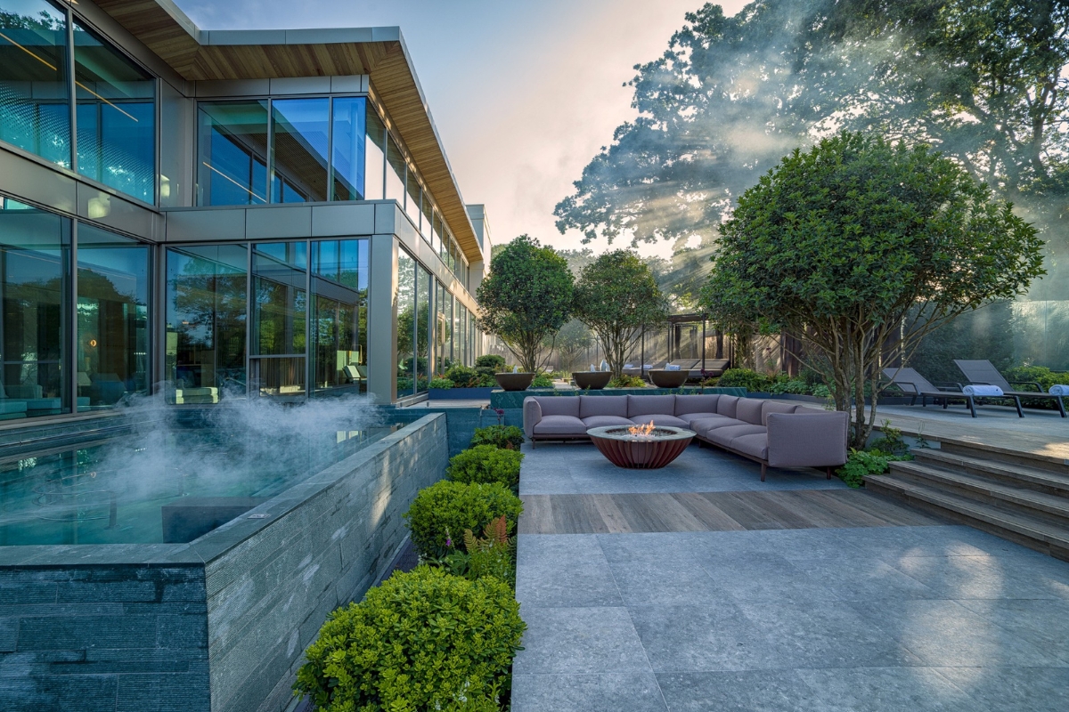 a patio with a fire pit and a large glass building