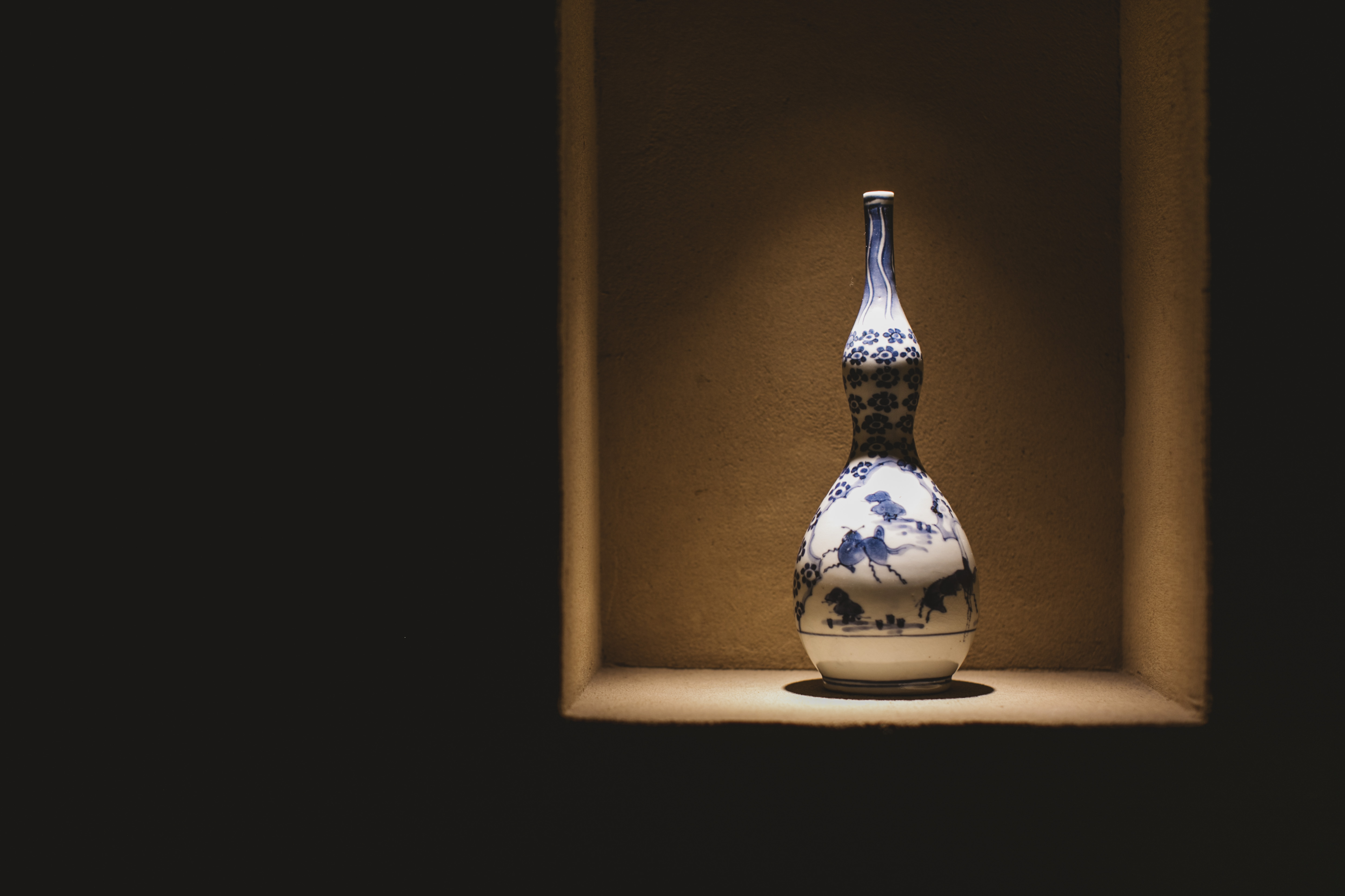 a blue and white vase on a shelf