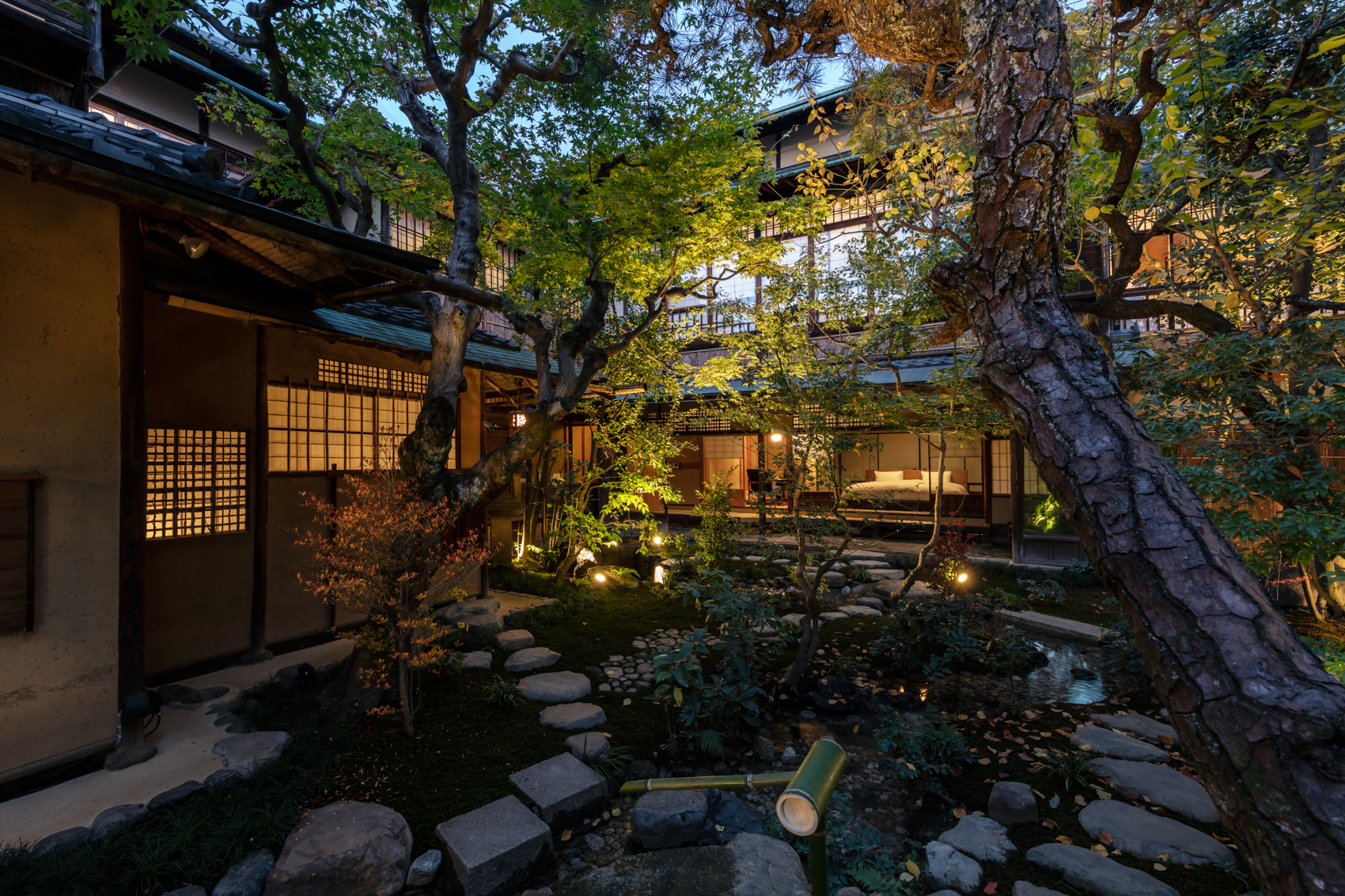 a courtyard with trees and a bed