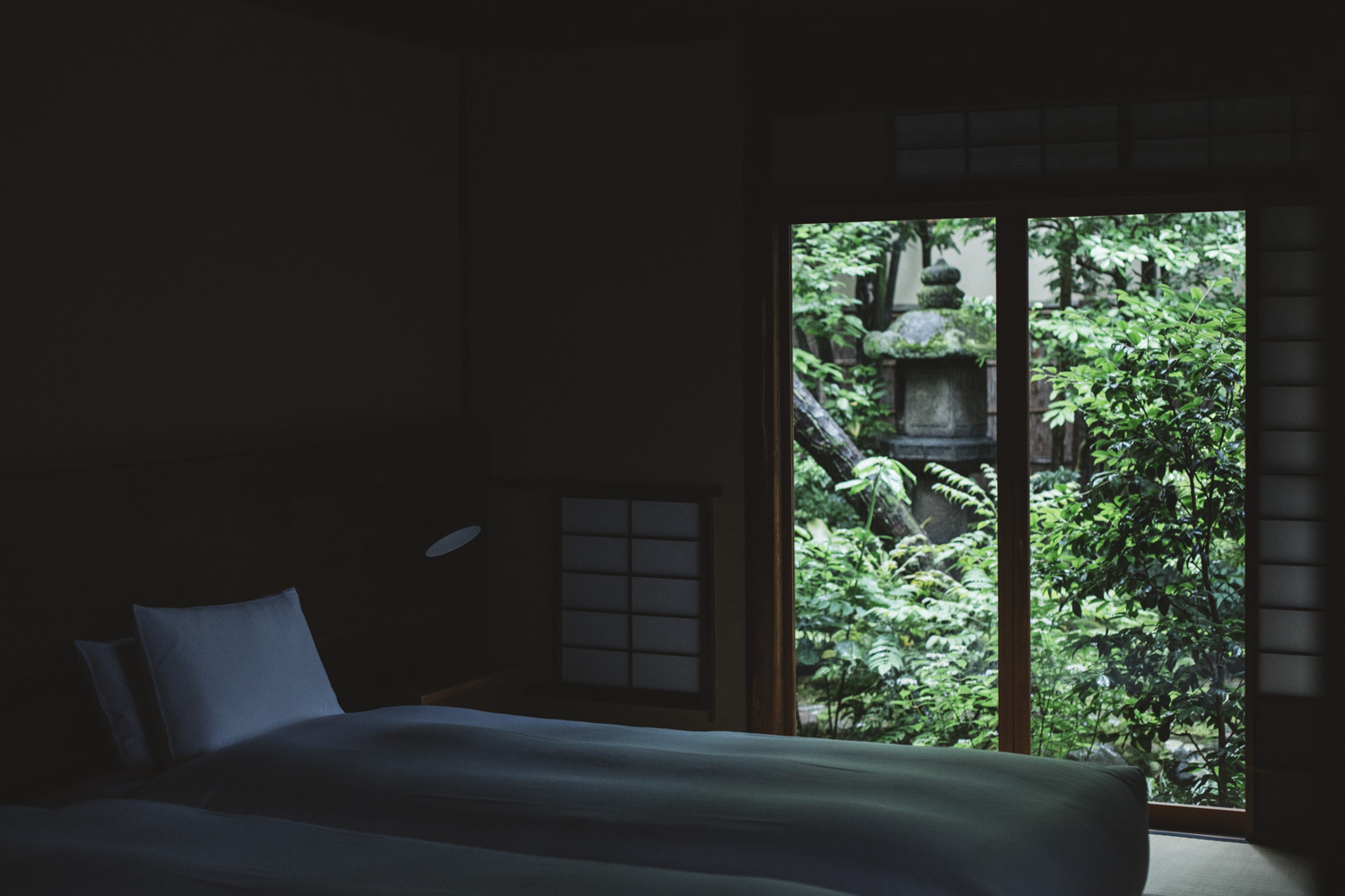 a bed in a dark room with a window