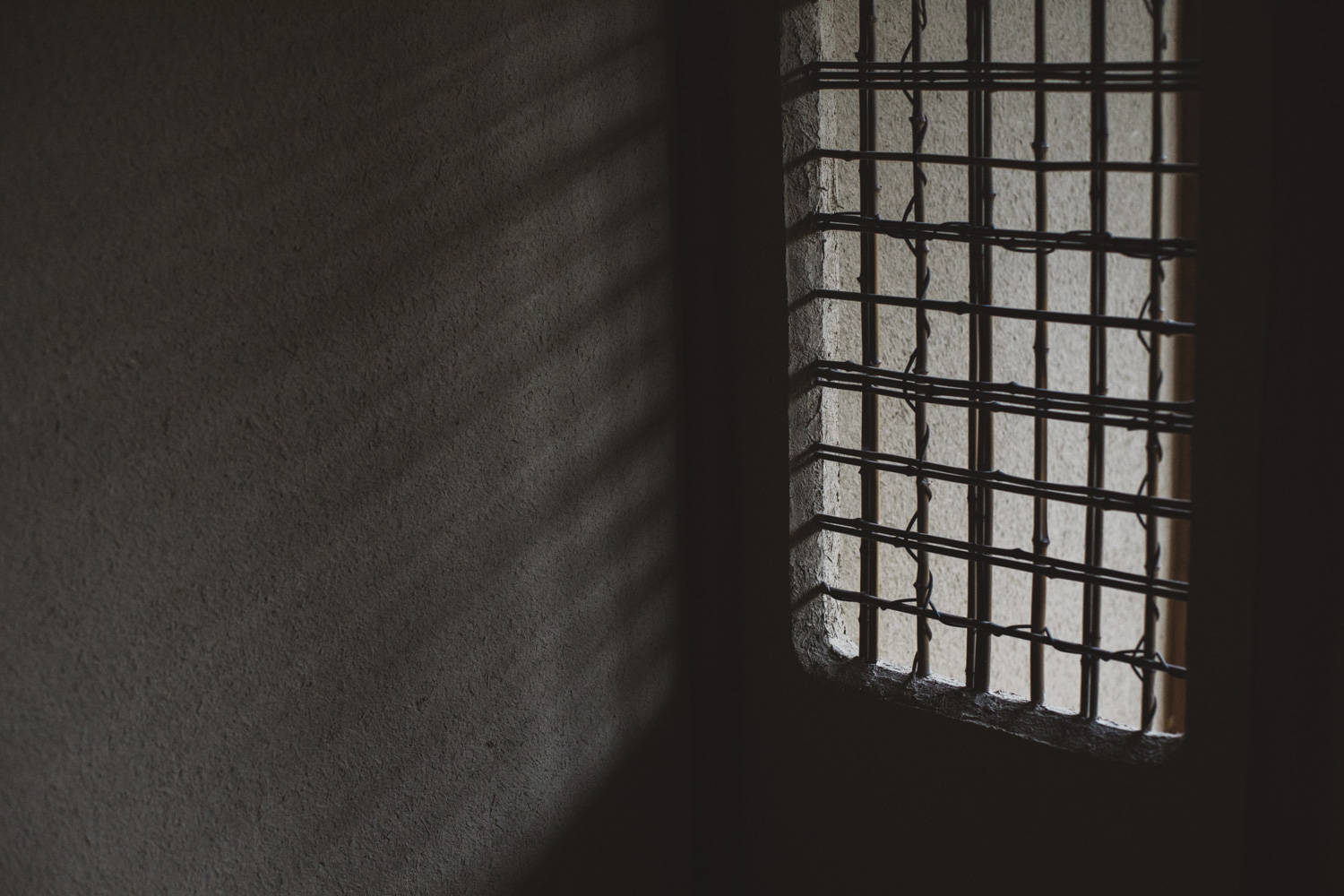 a window with bars in a dark room