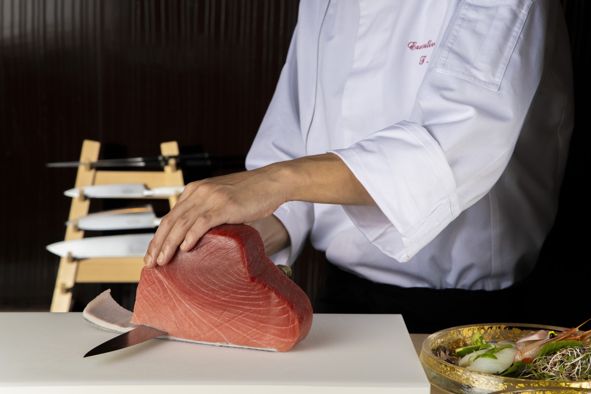 a chef slicing a piece of tuna