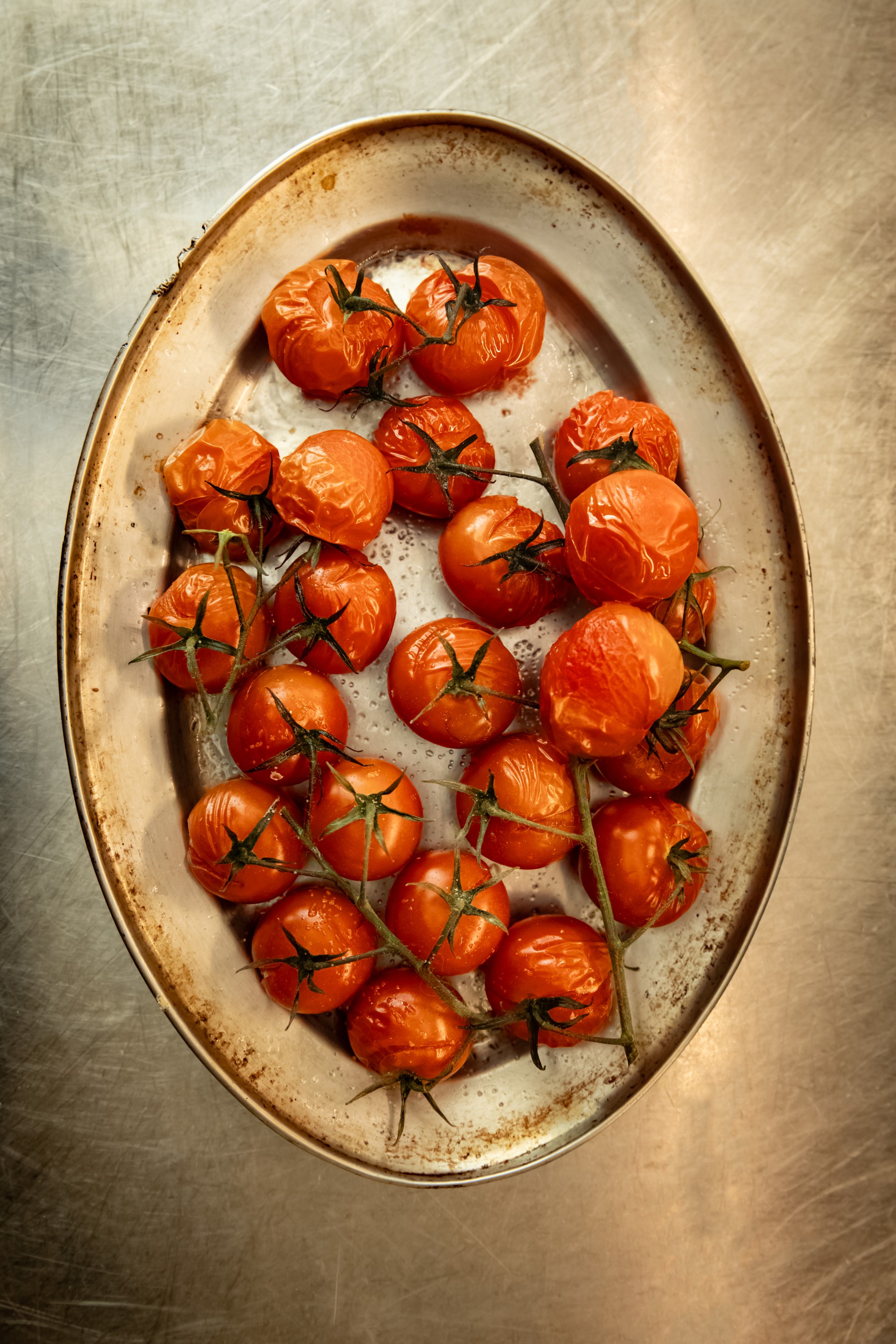 a plate of tomatoes on a metal surface