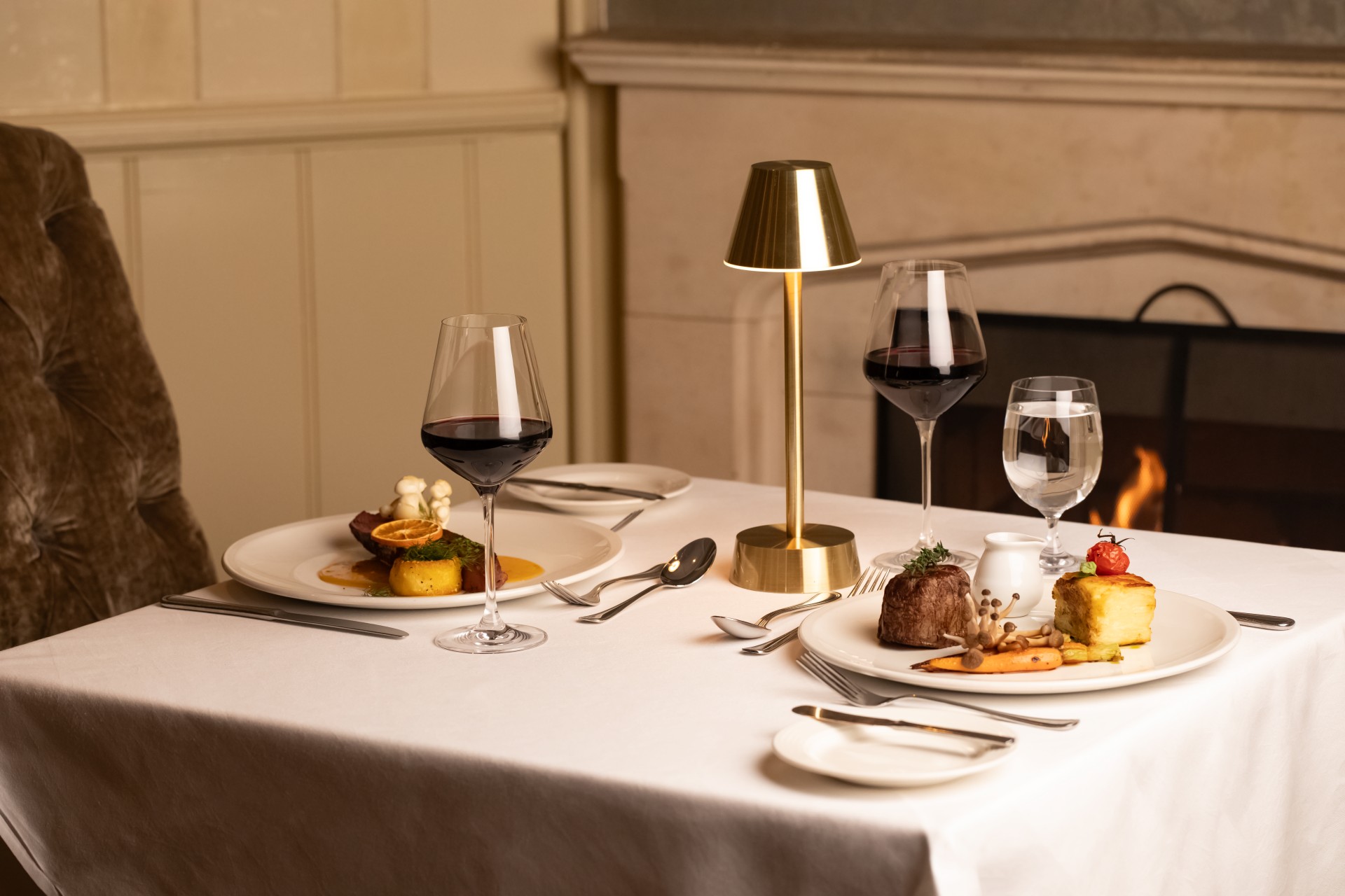 a table with plates of food and wine glasses