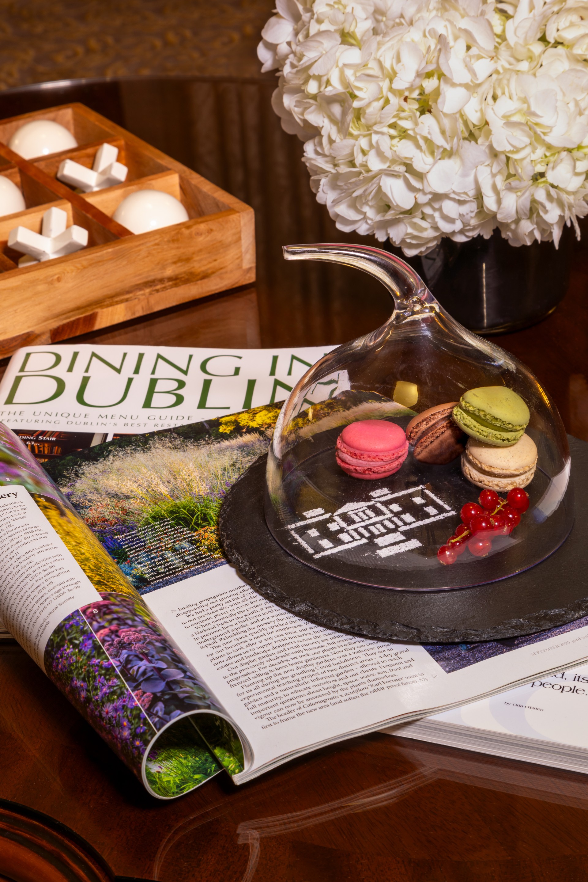 a glass dome with food inside on top of a magazine