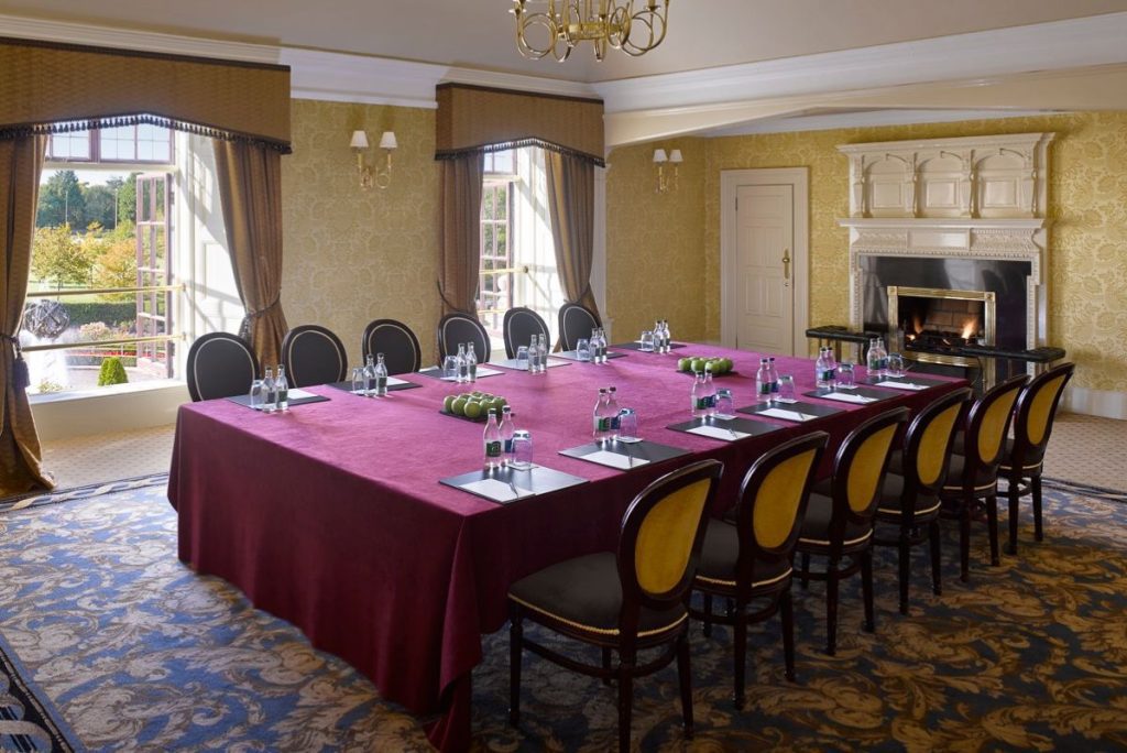 a large conference room with a red tablecloth and chairs