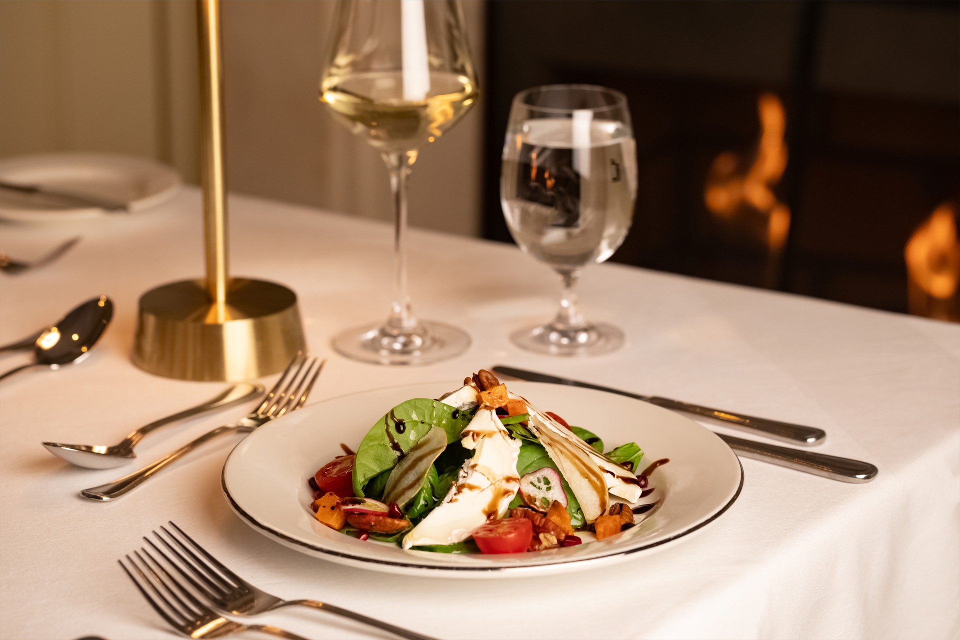 a plate of salad and wine glasses on a table